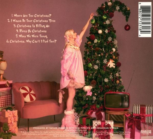 Eine Frau in Rosa schmückt einen Weihnachtsbaum. Geschenke und ein Fernseher sind unten. Eine Couch und Text sind links.