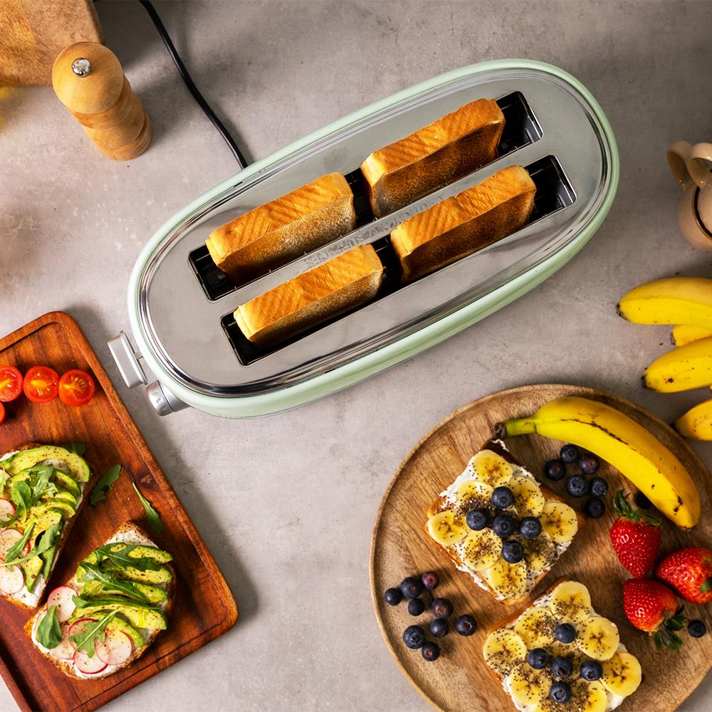 Tostadora con tostadas, tostadas de aguacate y tostadas de plátano en tablas de madera. También hay fresas, arándanos y plátanos.