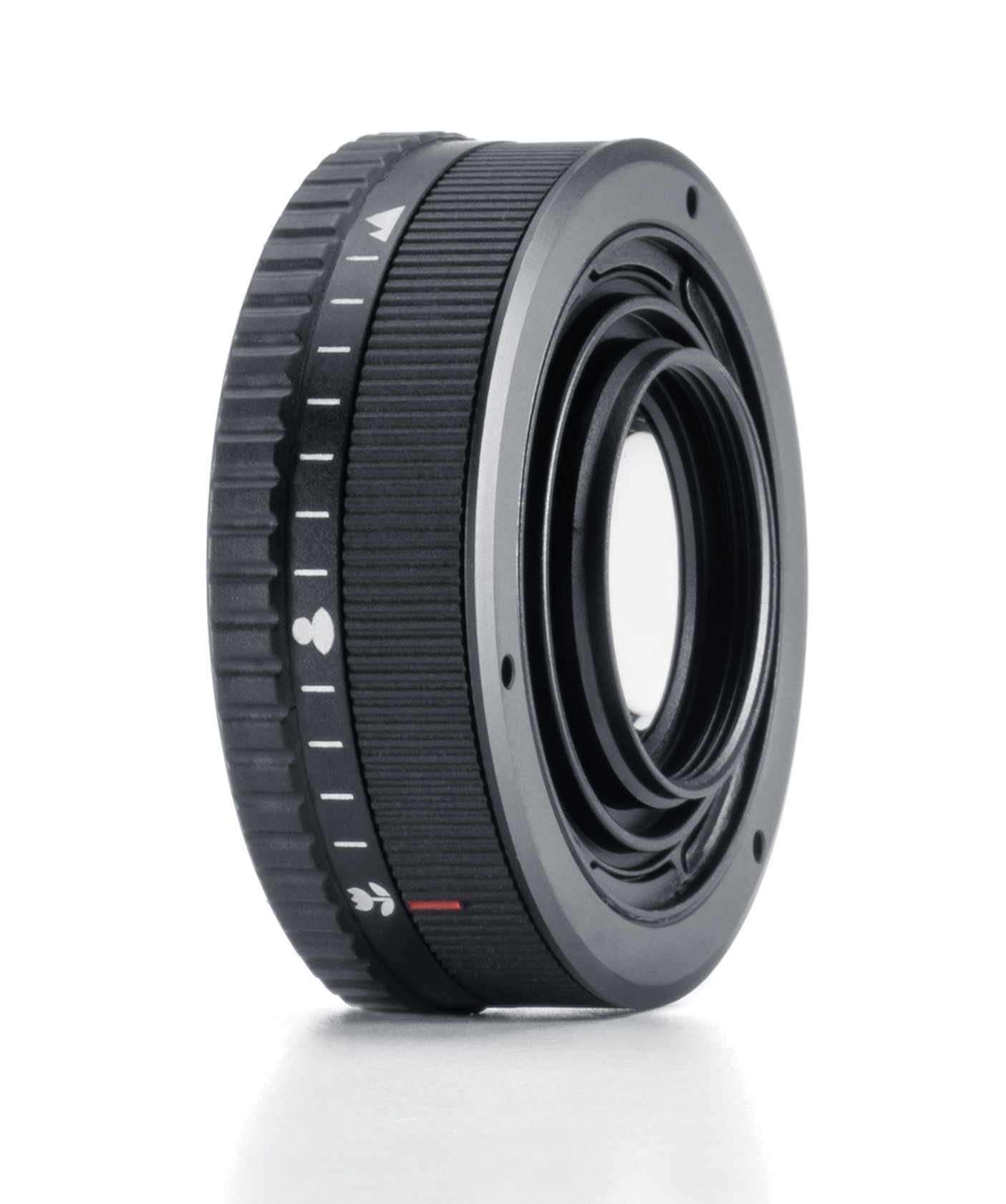 Czarny adapter obiektywu aparatu z białymi oznaczeniami i czerwoną linią, z widocznym otworem obiektywu. Leży na białym tle.