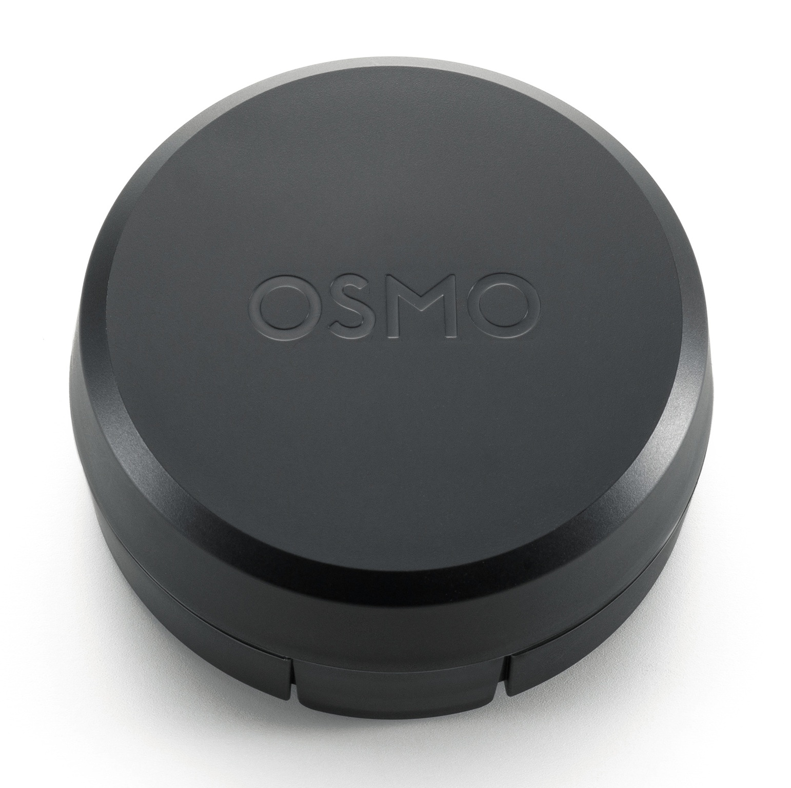 Czarna osłona obiektywu Osmo, okrągła, z wytłoczonym napisem 'OSMO'. Na białym tle.
