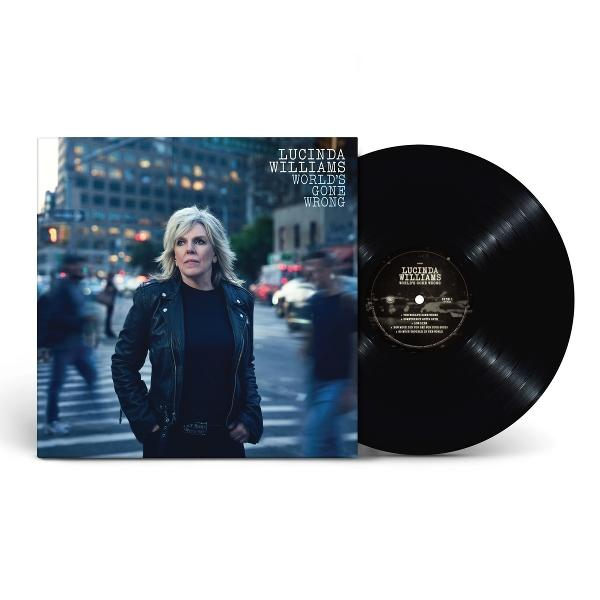 Lucinda Williams Album 'World's Gone Wrong' mit Schallplatte. Williams steht auf einer Stadtstraße und trägt eine schwarze Jacke.