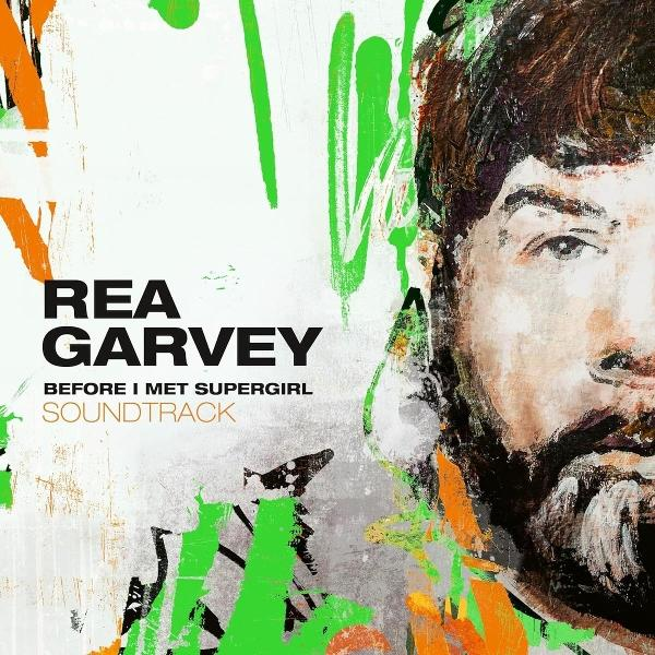 Albumcover für Rea Garvey. Porträt mit Bart und grünen, orangen Strichen. Text: Rea Garvey, Before I Met Supergirl, Soundtrack.
