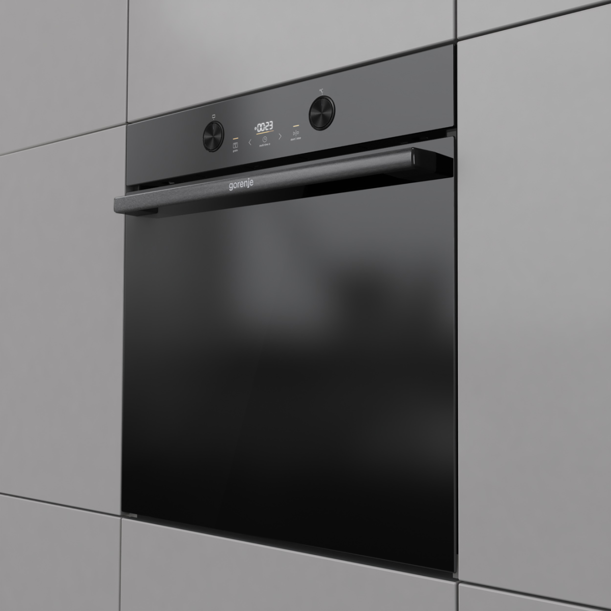Fekete Gorenje sütő a szürke konyhaszekrénybe építve. A sütő digitális kijelzővel és fogantyúval, valamint vezérlőgombokkal rendelkezik.