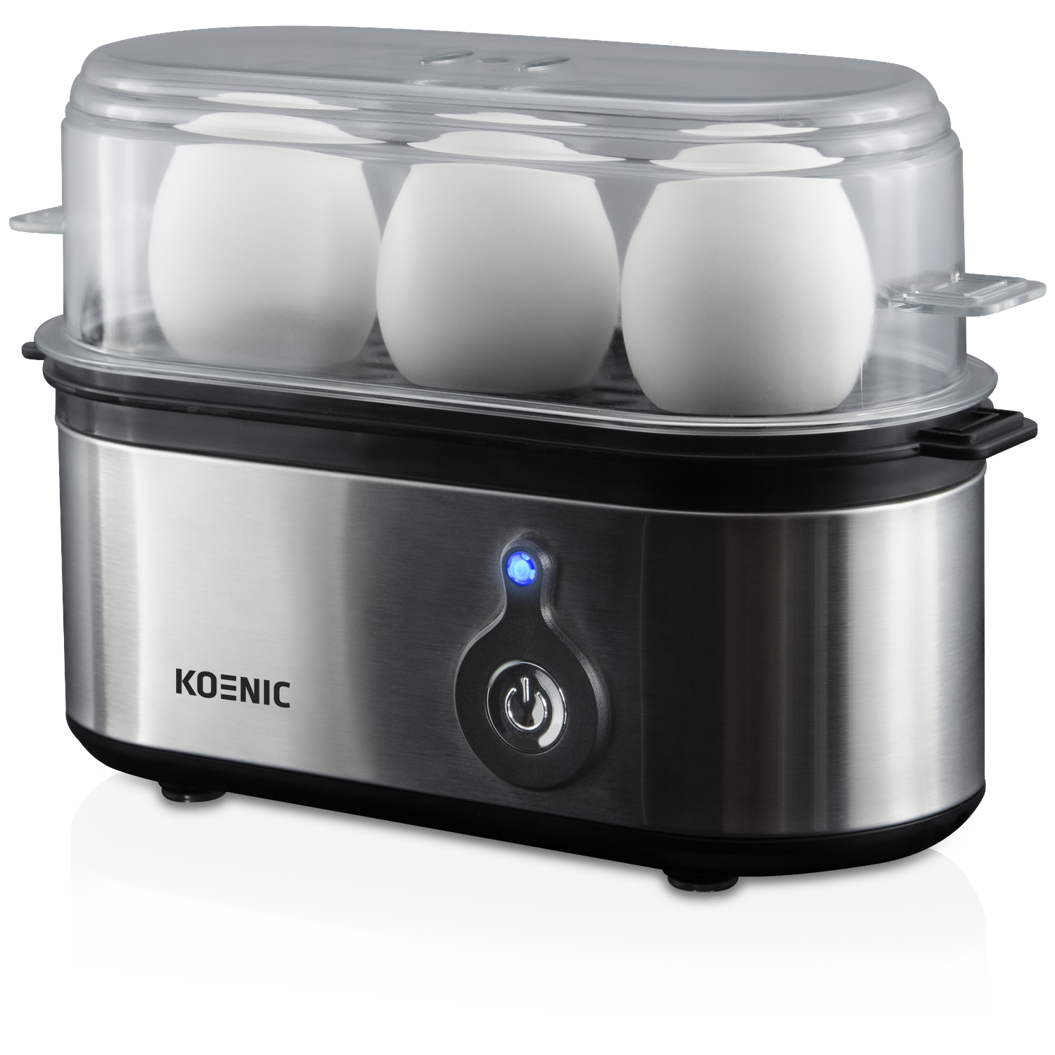 An egg cooker with three eggs inside. It has a transparent lid and a silver base with a power button.