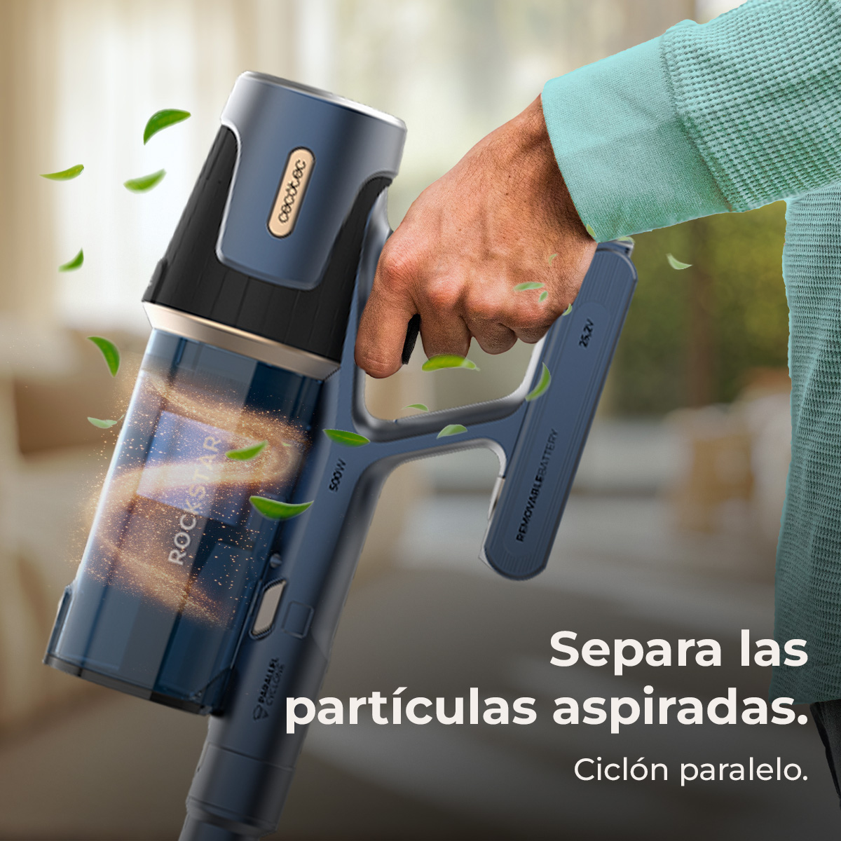 Una persona sostiene una aspiradora azul y negra con el nombre Rockstar visible. Hojas verdes flotan alrededor de la aspiradora.