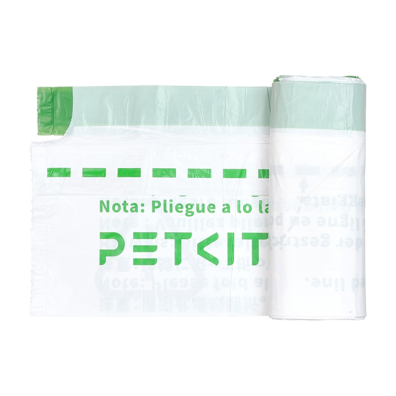 Fehér műanyag zacskók tekercse zöld díszítéssel. A zacskókon a 'PETKIT' felirat és spanyol nyelvű utasítások láthatók.