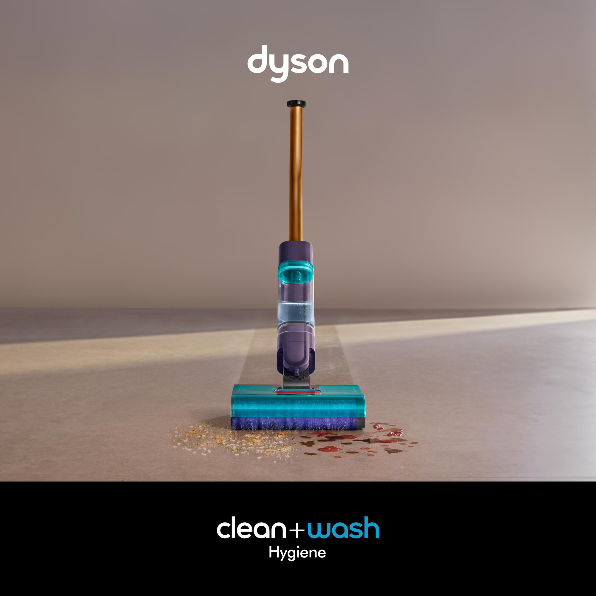 Dyson Clean+Wash Staubsauger, der eine Oberfläche mit Schmutz reinigt. Der Staubsauger ist lila, blaugrün und gold.