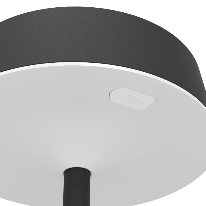 Nahaufnahme einer weiß-schwarzen Lampe. Ein USB-Anschluss ist auf der Unterseite sichtbar. Schwarzer Ständer unten.