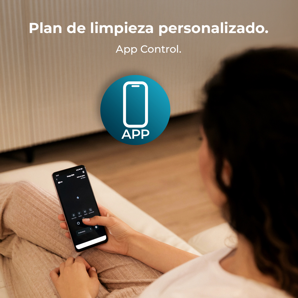 Mujer usa aplicación telefónica para plan de limpieza. Teléfono en el regazo. Círculo azul con icono de teléfono y texto APP.