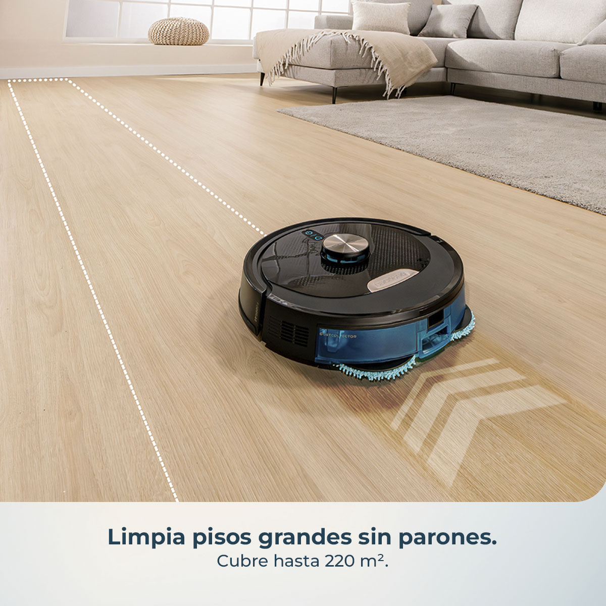 Una aspiradora robot negra y azul limpia un piso de madera. Un sofá gris y una alfombra están al fondo. Líneas punteadas blancas muestran el área limpia.