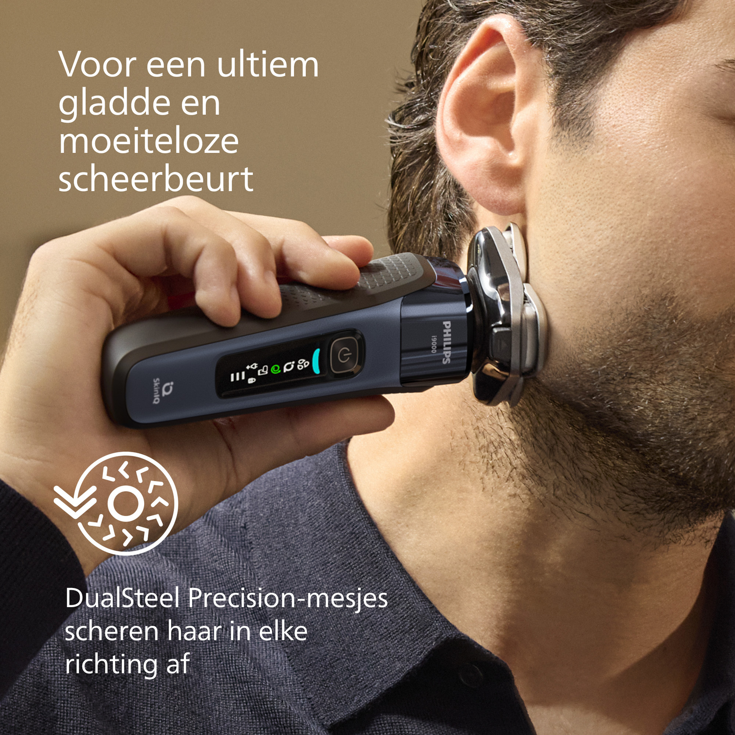 Een man scheert zijn gezicht met een Philips-scheerapparaat. Het scheerapparaat wordt voor zijn oor gehouden. De achtergrond is neutraal.