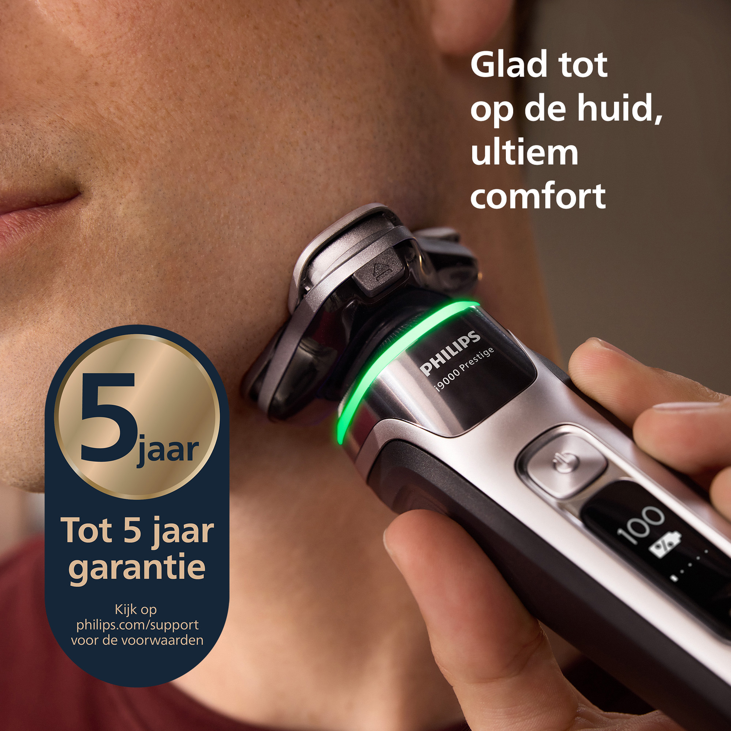 A man shaves with a Philips electric shaver. Text on the shaver says Philips 9000 Prestige. A badge says 5 year warranty.