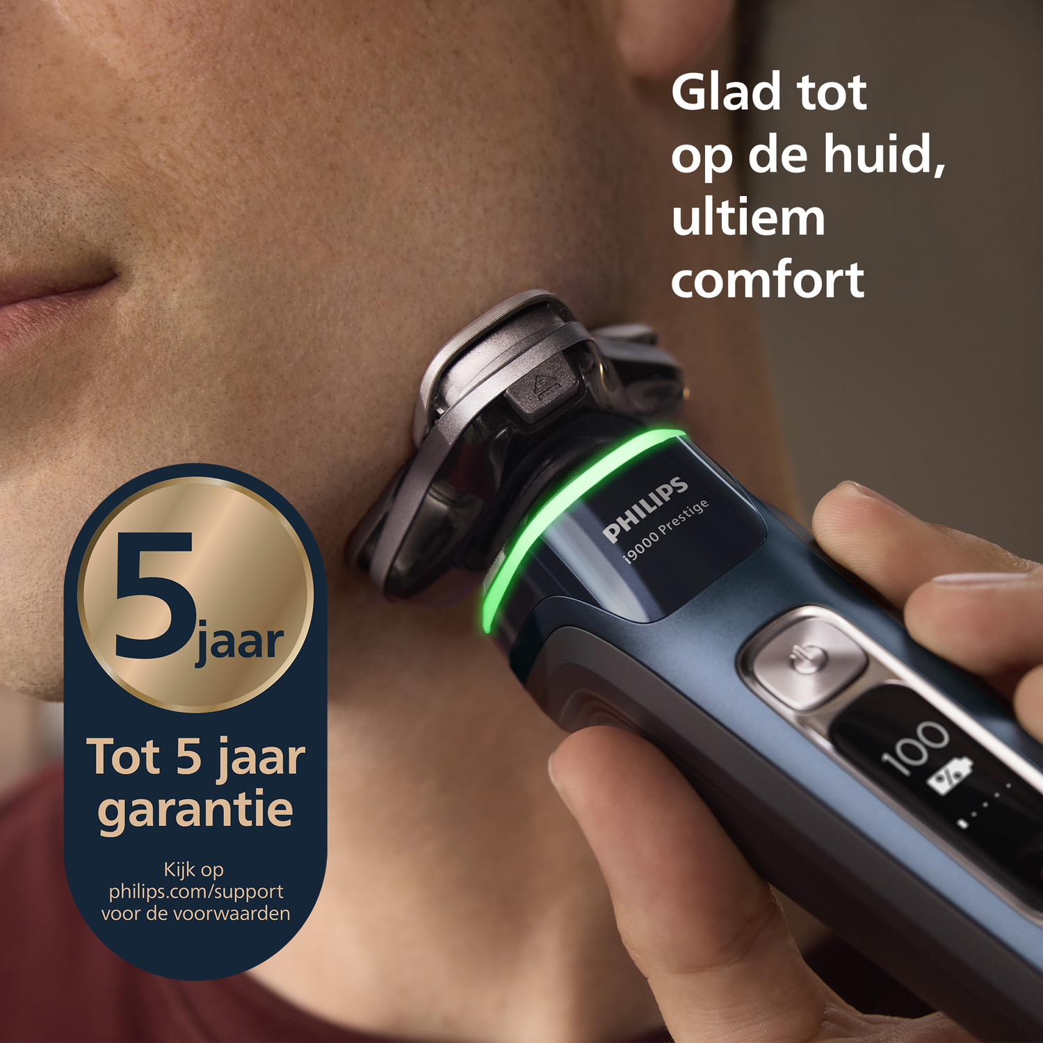 A man shaves with a Philips shaver. The shaver has a green light. Text reads '5 jaar garantie'. The background has text 'Glad tot op de huid'.