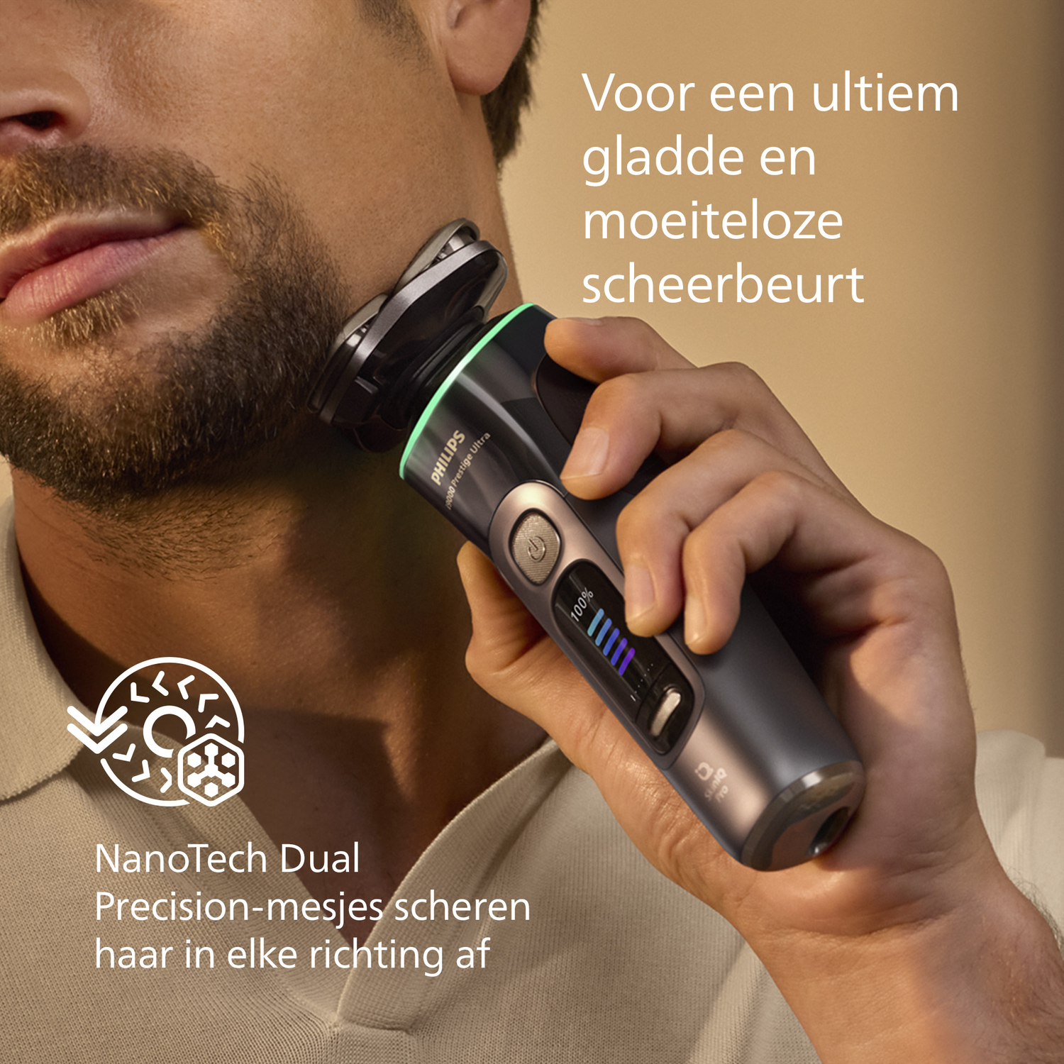 A man shaves his beard with a Philips shaver. The shaver is gray and black. Text says NanoTech Dual Precision-mesjes.