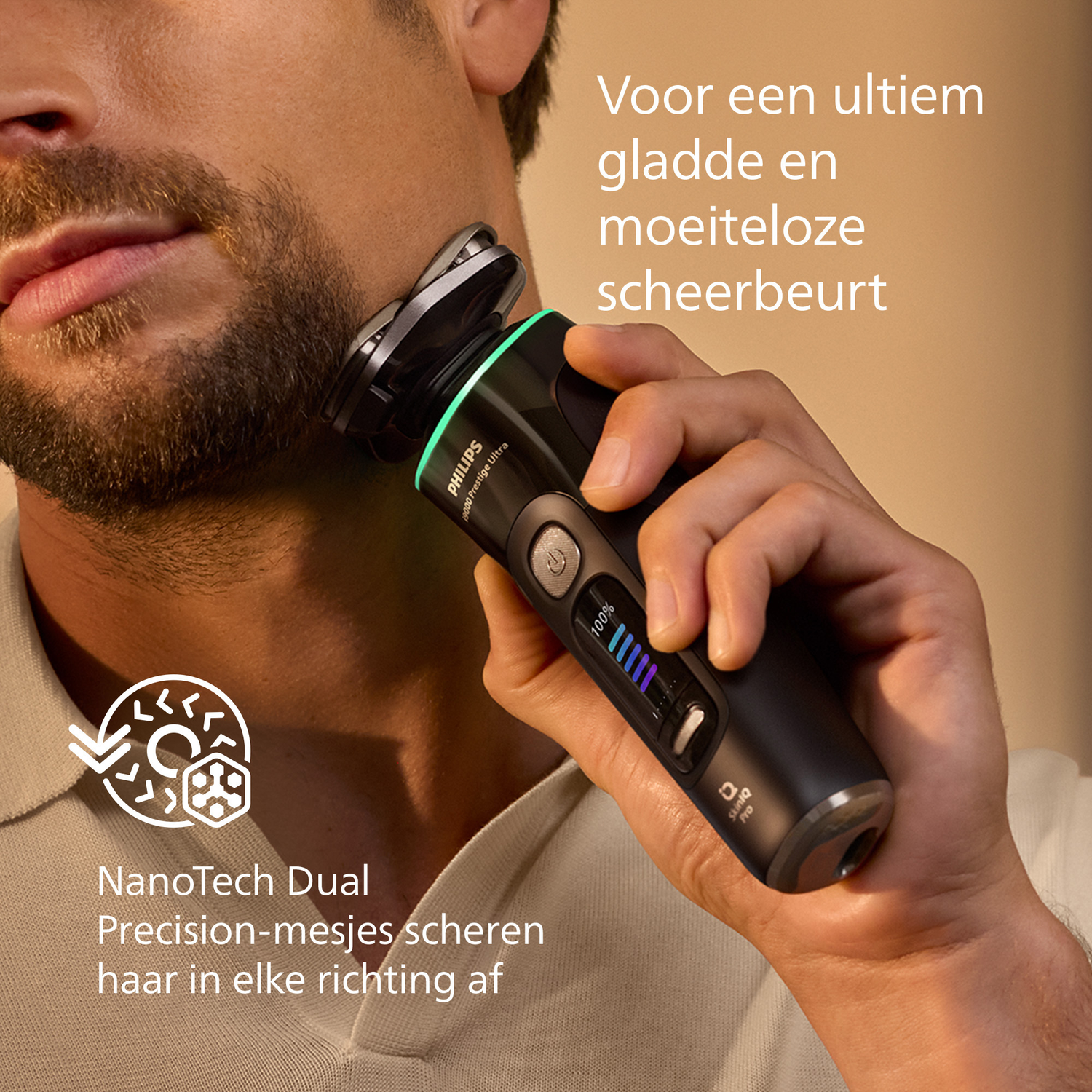 A man shaves his beard with a Philips shaver. The shaver is black and silver. The man's skin is visible as he shaves.