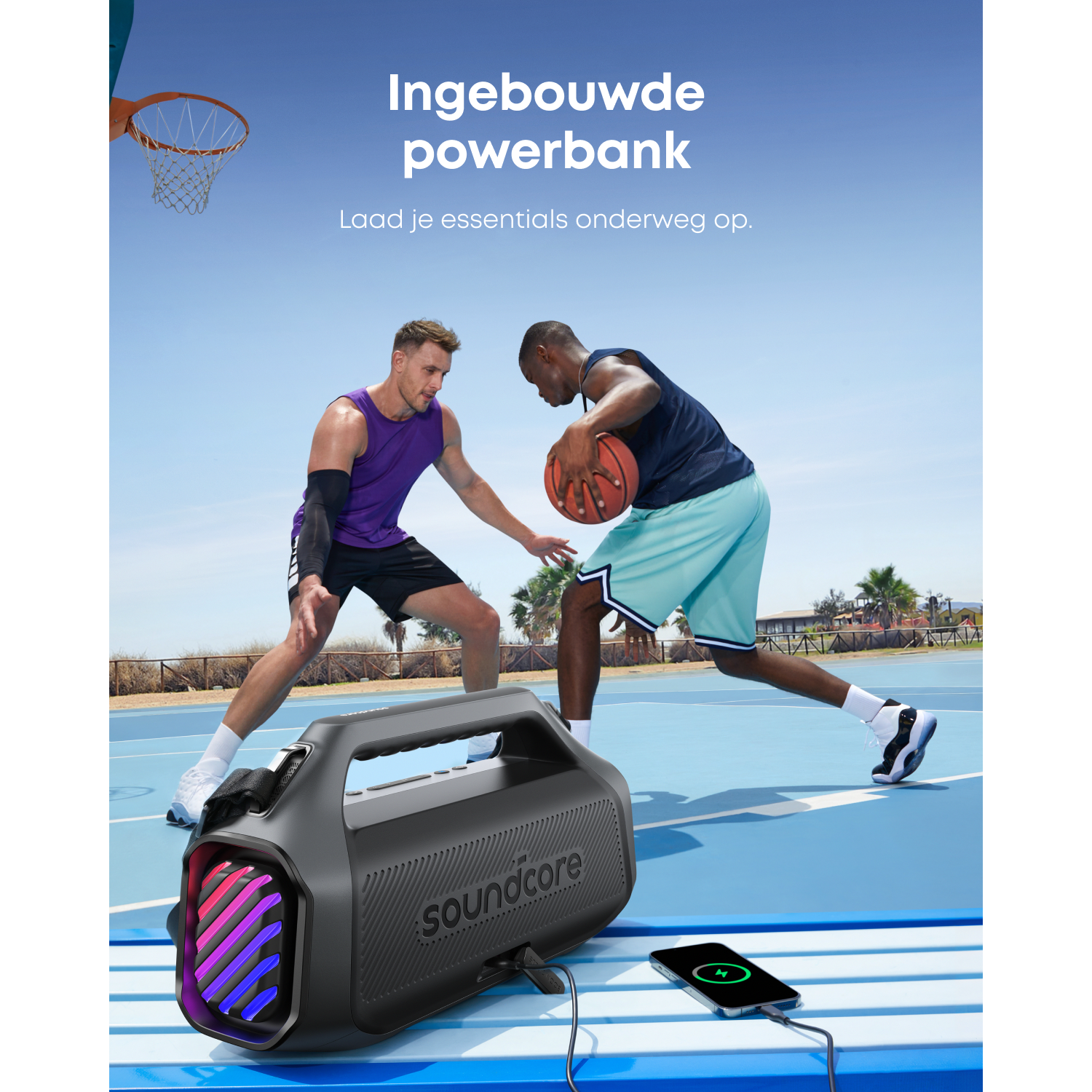 Twee mannen spelen basketbal in de buurt van een soundcore speaker. Een telefoon wordt opgeladen. Blauwe baan, heldere lucht. Productplaatsing.