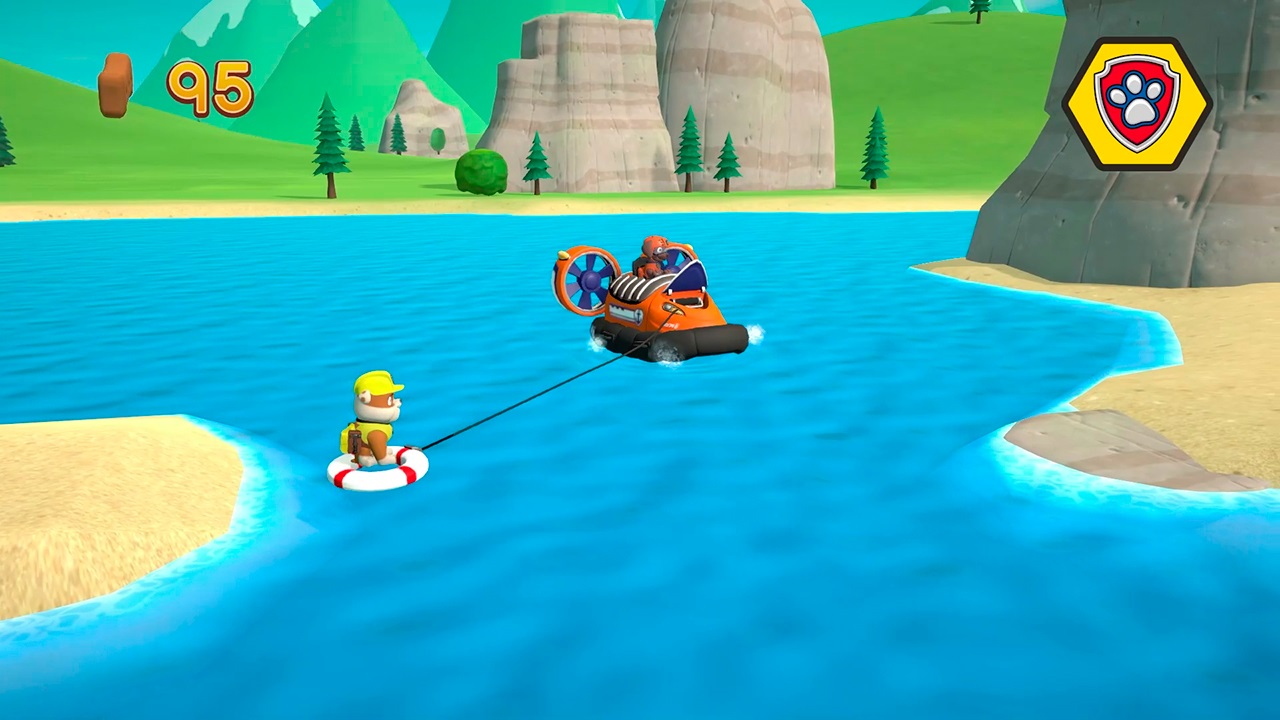 Paw Patrol-Szene: Eine Figur auf einem Rettungsring wird von einem orangefarbenen Hovercraft geschleppt. Ein Berg und Strand im Hintergrund.