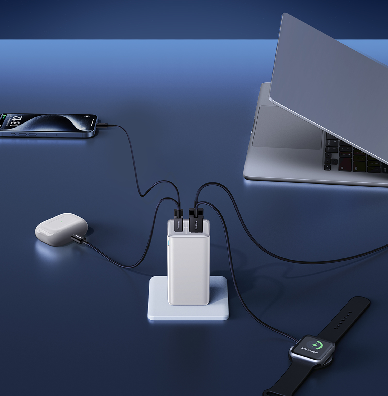 Un teléfono, auriculares, una laptop y un reloj inteligente se están cargando. Un cargador blanco está en un soporte blanco. El fondo es azul.