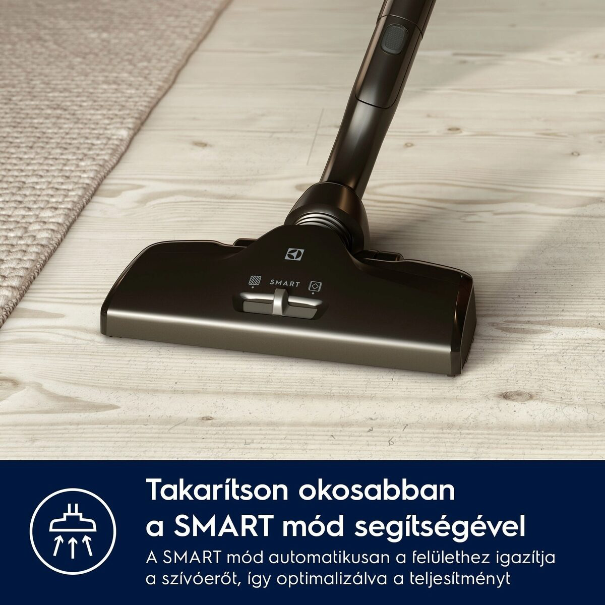 Fekete porszívófej fapadlón, szőnyeg közelében. A szöveg szerint: 'Takarítson okosabban a SMART móddal'.