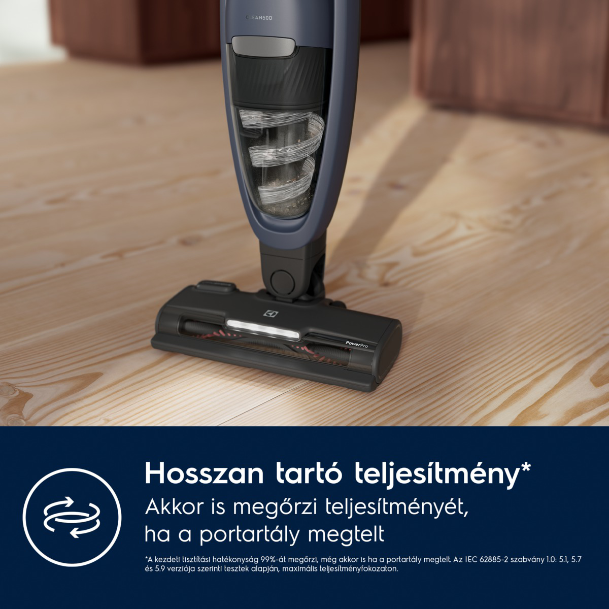 Egy vezeték nélküli porszívó közeli képe. A porszívó sötétkék és fekete, a feje fa padlón van. Szöveg alul.