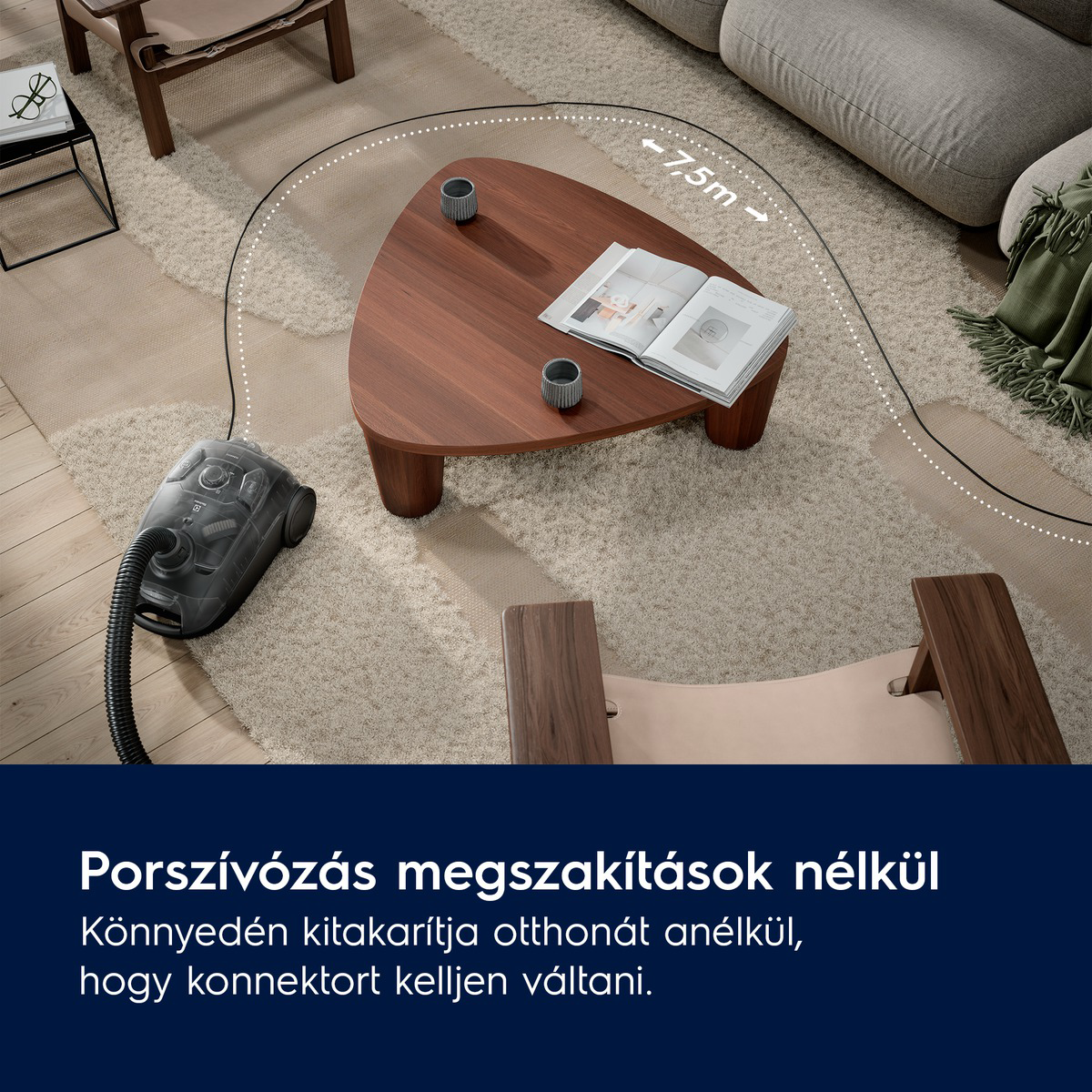 Porszívó a szőnyegen. Dohányzóasztal bögrékkel és könyvvel. Kanapé és székek is láthatók.