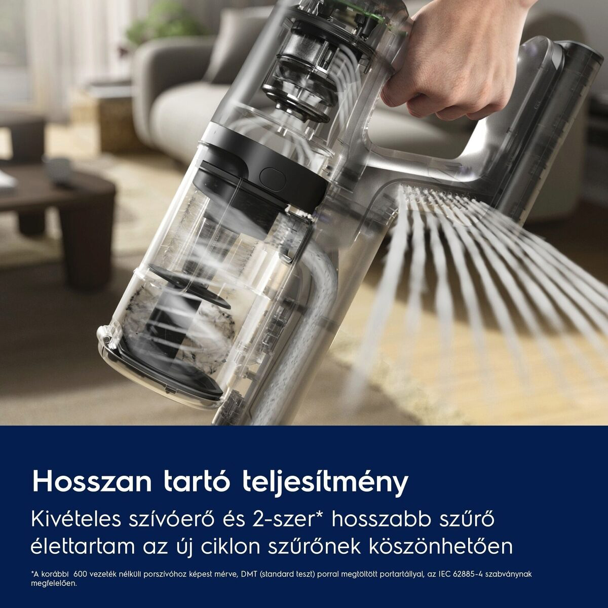 Egy átlátszó porszívó látható, amelyet egy kéz tart. A porszívó részben szétszerelt, belső alkatrészeket és port mutatva.