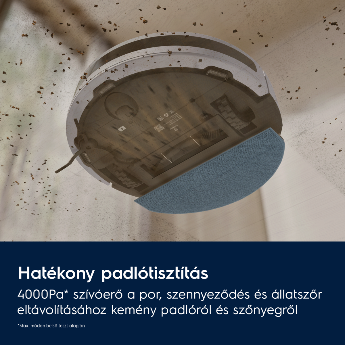 Egy robotporszívó kék tisztítópaddal piszkos padlót takarít. A padlón apró törmelék látható.