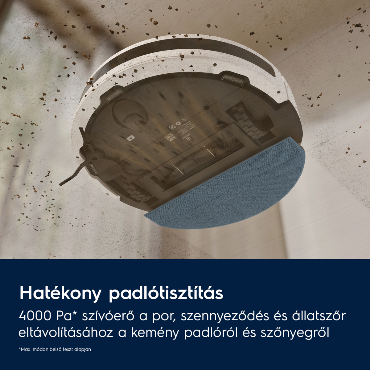 Egy robotporszívó egy piszkos padlót takarít. A tisztító fehér és szürke, kék tisztítópaddal. Törmelék szóródik.