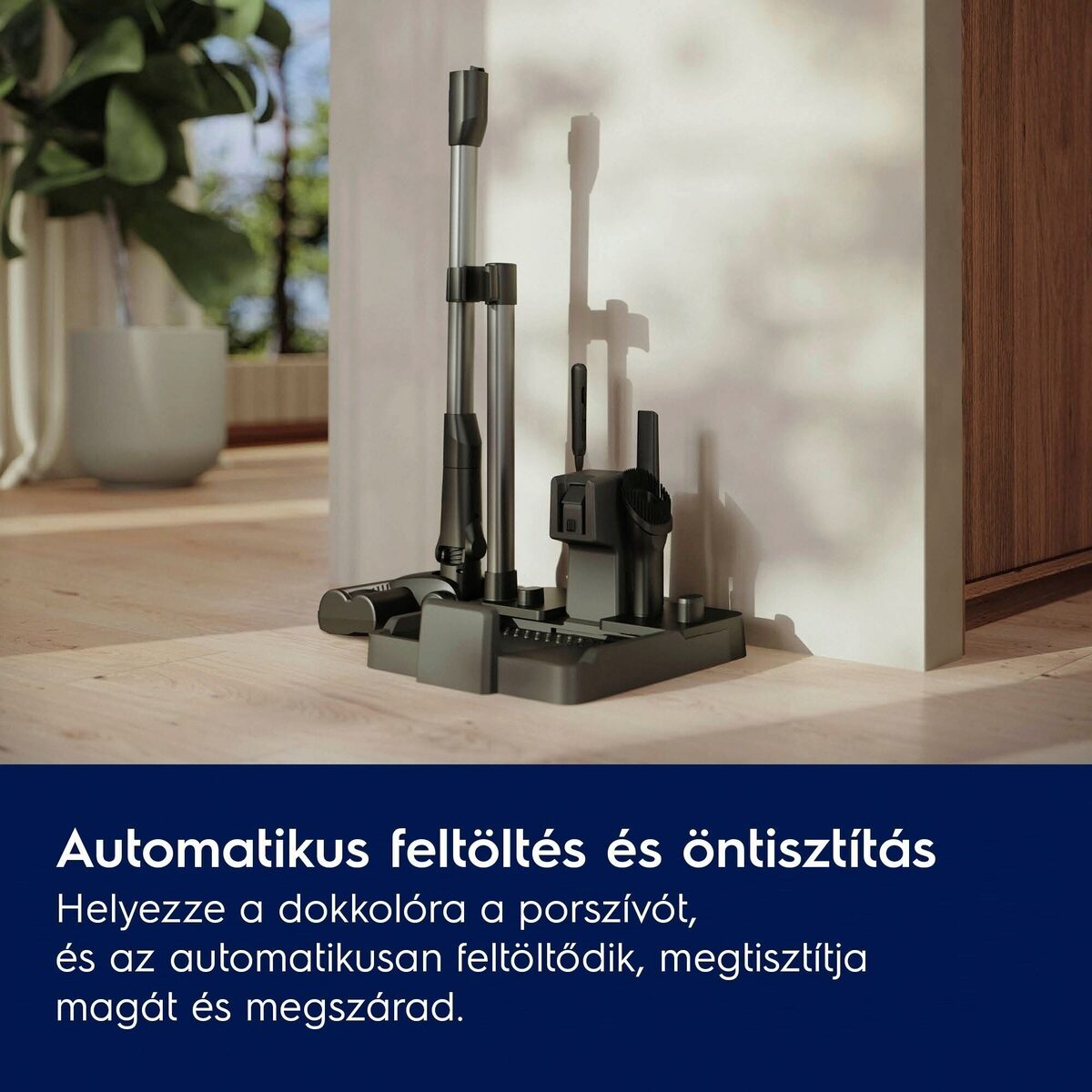Porszívó töltőállomással. A töltőállomás egy fa padlón van, egy fehér fal és egy fa szekrény mellett.