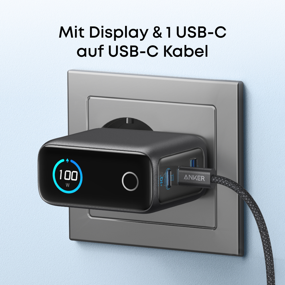 Schwarzes Anker-Ladegerät in einer grauen Steckdose. Das Ladegerät hat ein Display mit 100W. Ein USB-C-Kabel ist angeschlossen.