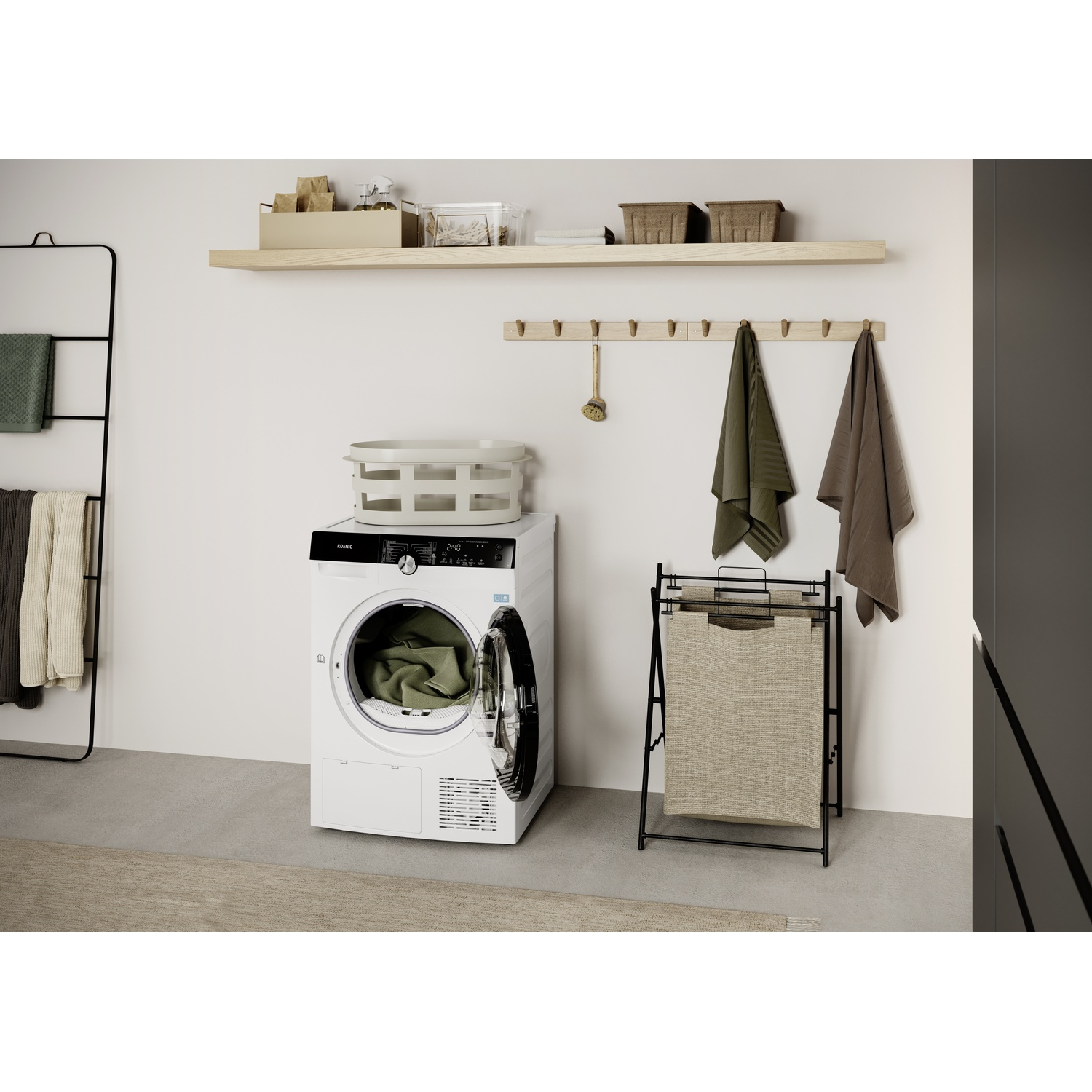 A white washing machine with an open door stands near a black laundry rack and towels. A shelf holds baskets and boxes.