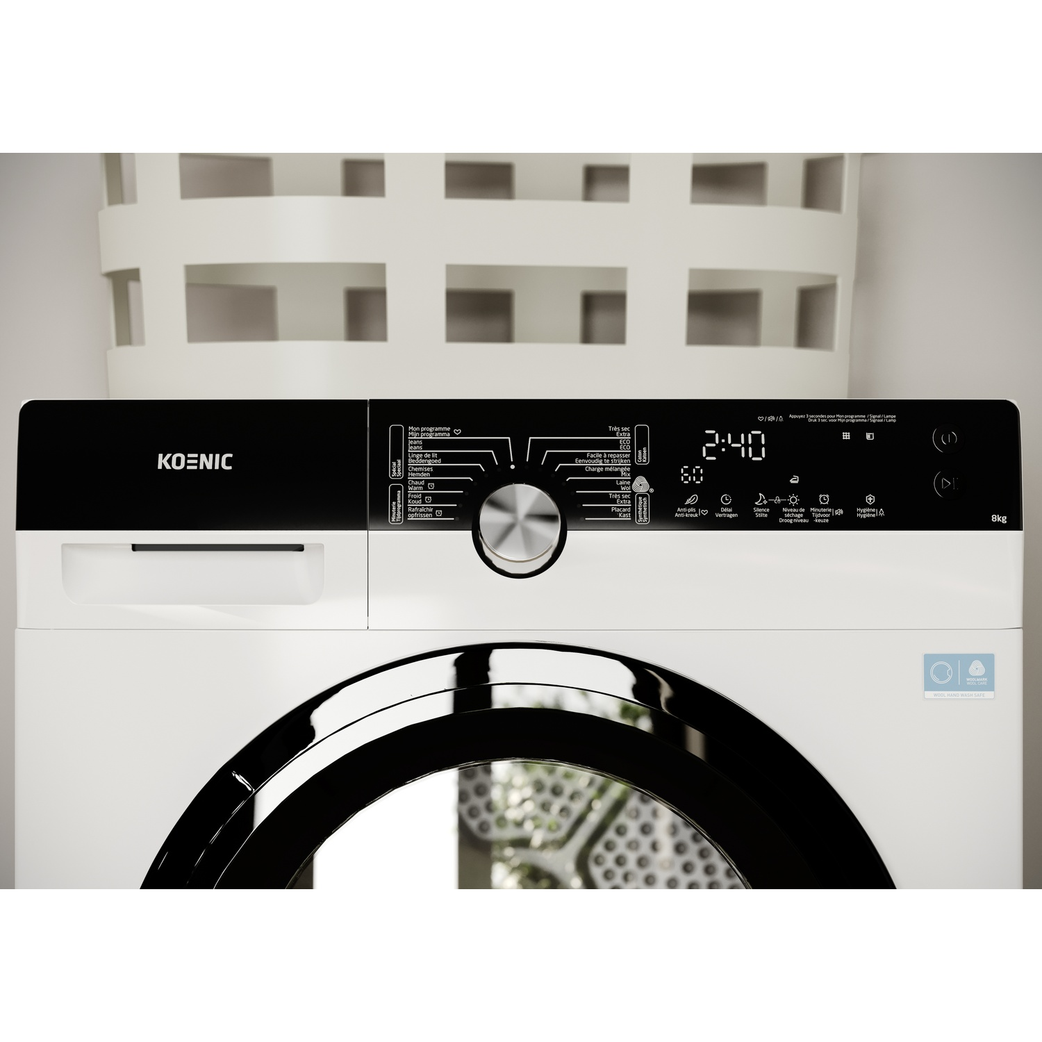 A white Koenic washing machine with a black door. It has a digital display showing 2:40 and a basket in the background.