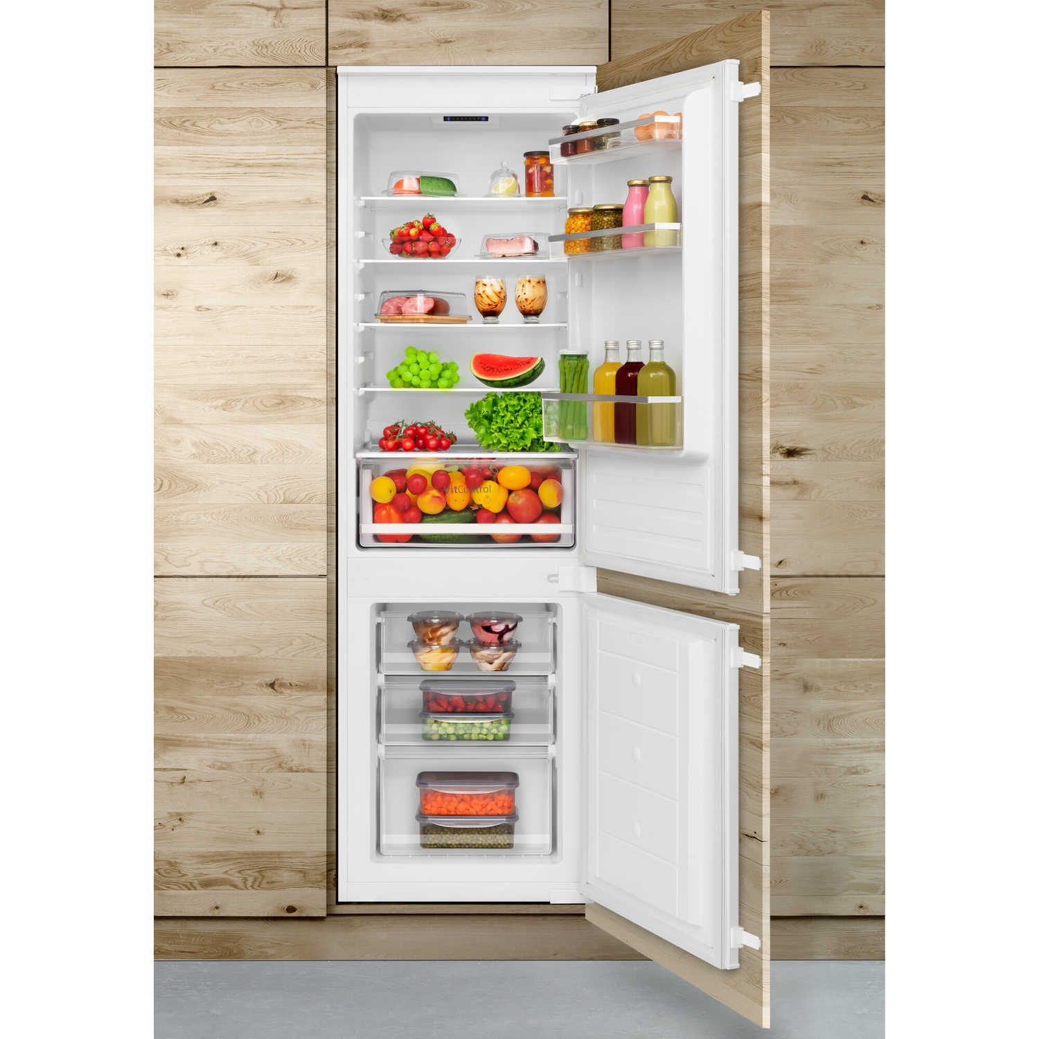 Open refrigerator filled with fruits, vegetables, and drinks. Wooden paneling surrounds the fridge. The door is open.