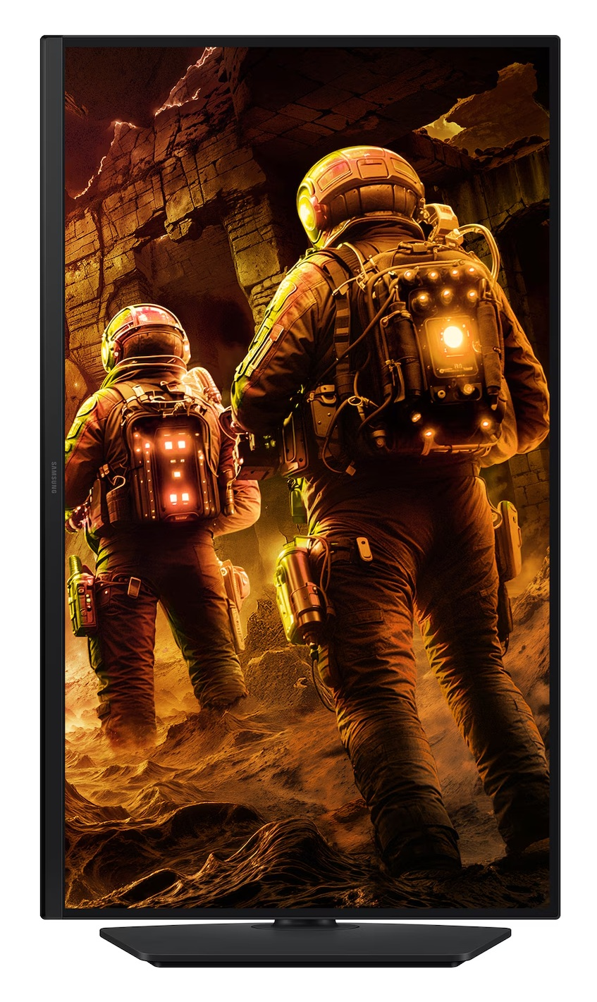 Dwóch astronautów w kombinezonach eksploruje skalisty, obcy krajobraz. Idą w kierunku jaskini. Scena jest oświetlona przez świecące światła.