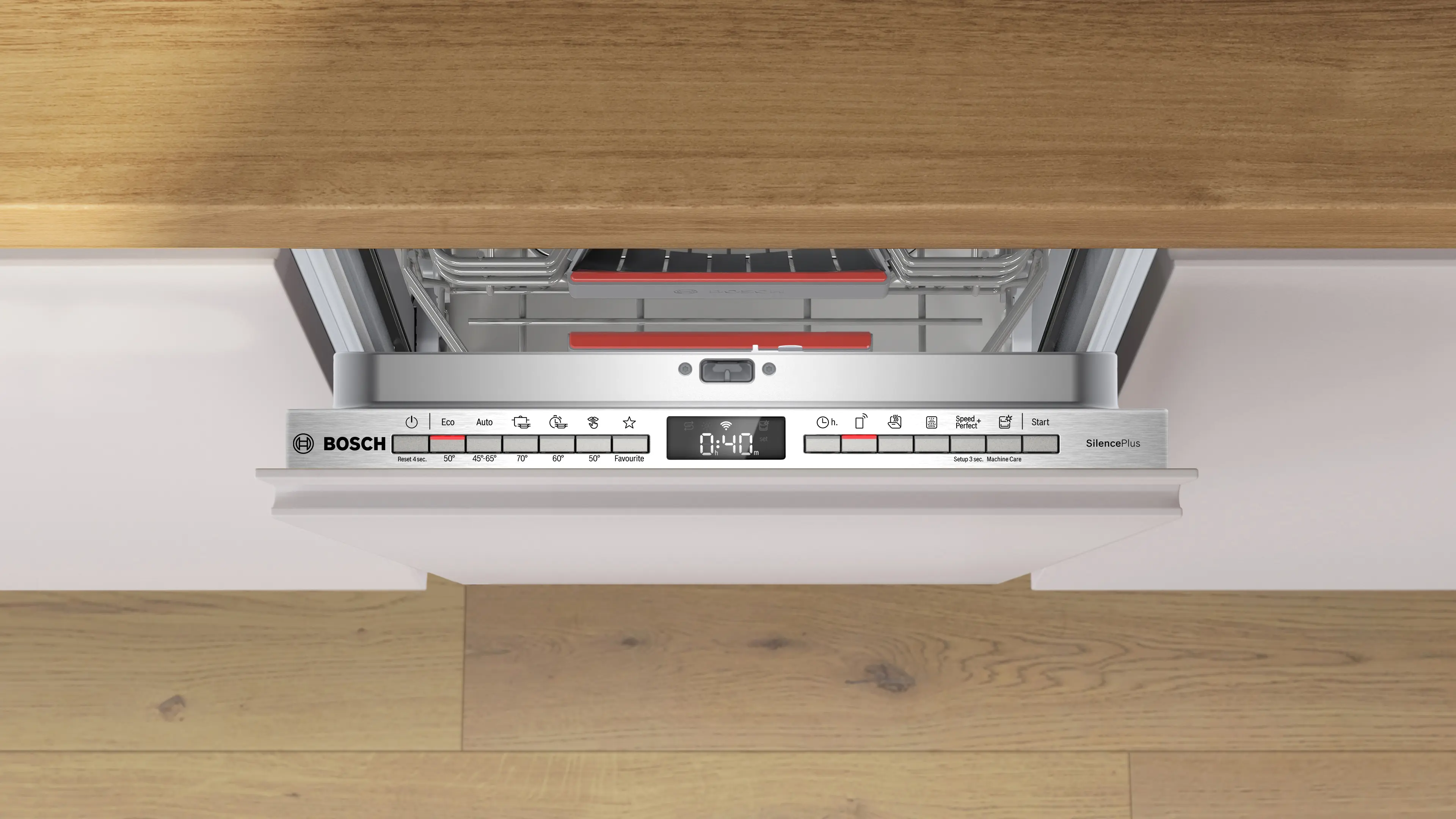Lavavajillas con puerta abierta. Controles y pantalla visibles. Encimera de madera, mueble blanco y suelo de madera.