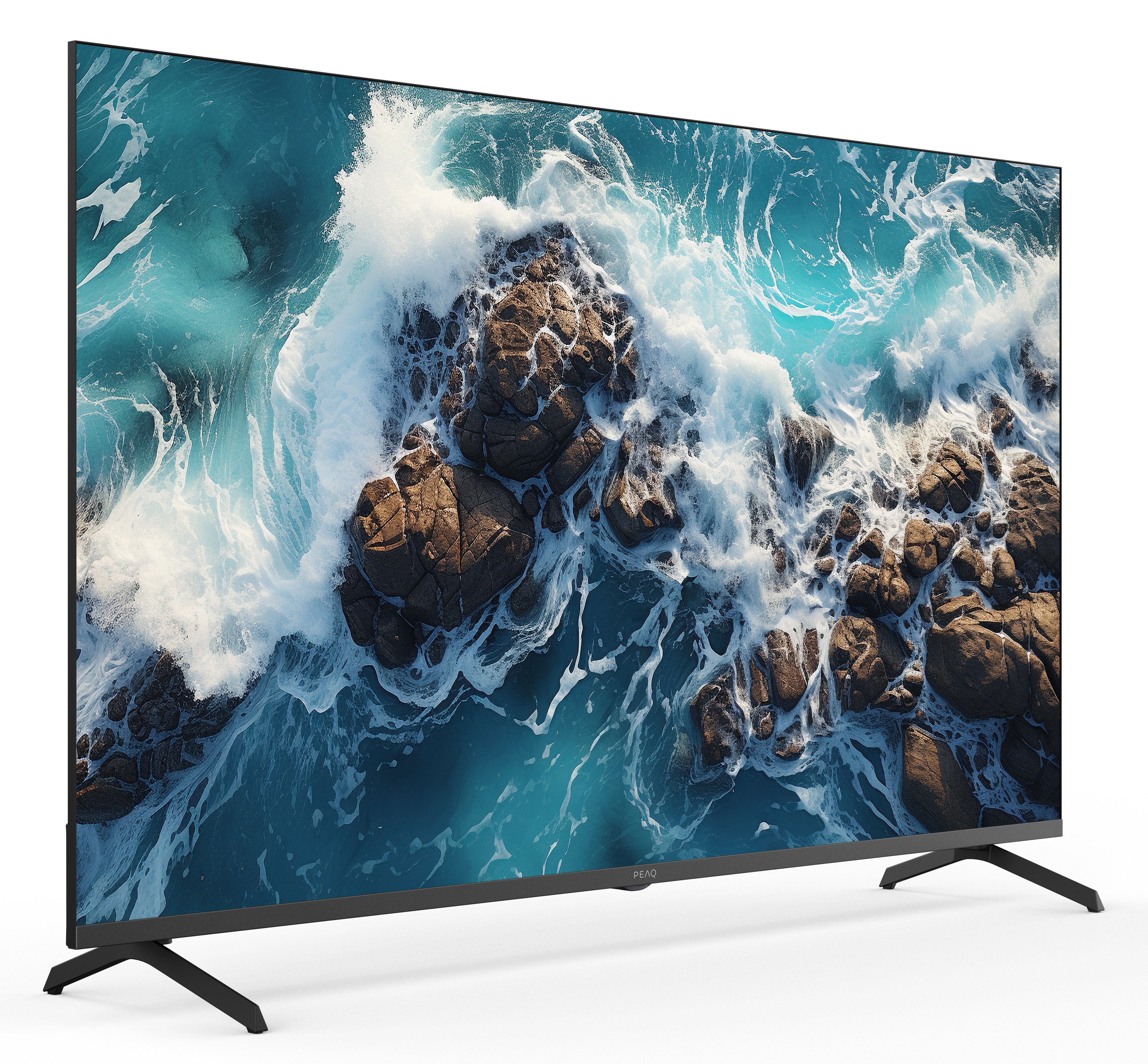 Telewizor wyświetla scenę oceanu. Fale rozbijają się o skały. Telewizor na białej powierzchni.