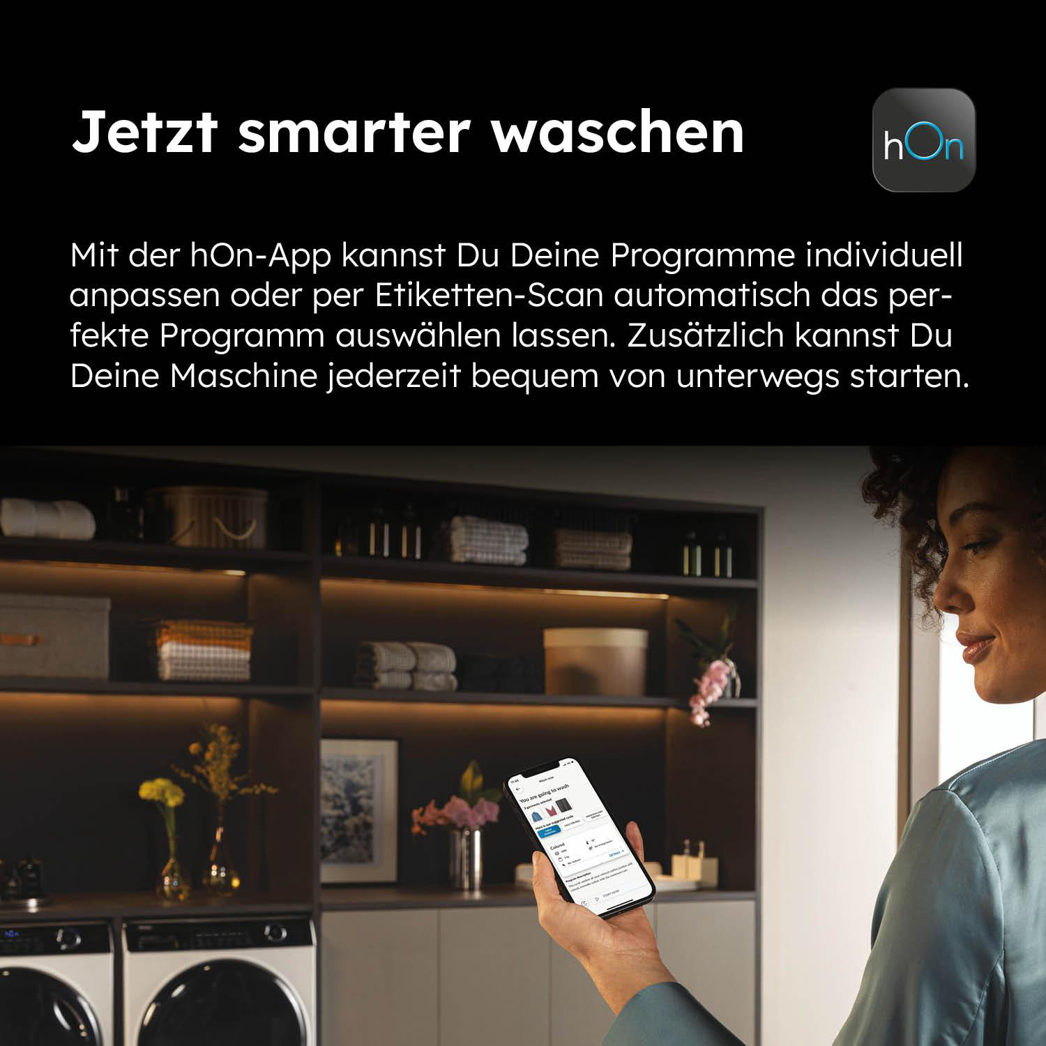 Eine Frau steuert eine Waschmaschine per Smartphone. Im Hintergrund sind Wäsche und Geräte zu sehen.
