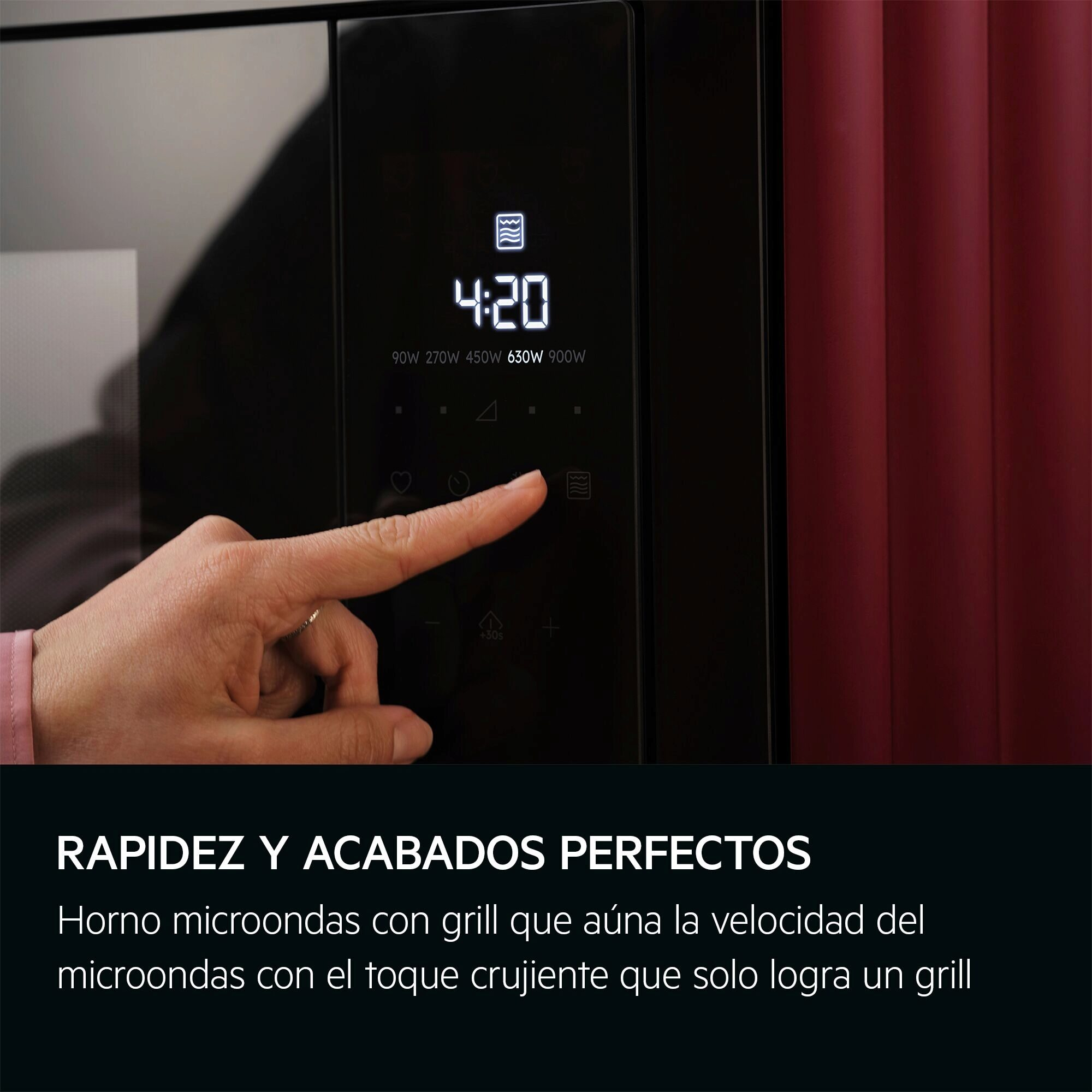 Una mano presiona un botón del microondas. La pantalla muestra 4:20. Cortina roja en el fondo.