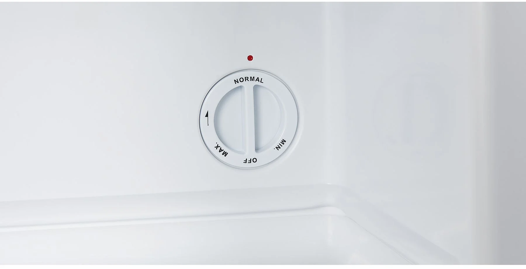 À l'intérieur d'un réfrigérateur blanc, un cadran blanc avec les textes 'NORMAL', 'MIN', 'OFF' et 'MAX'. Une lumière rouge est au-dessus du cadran.