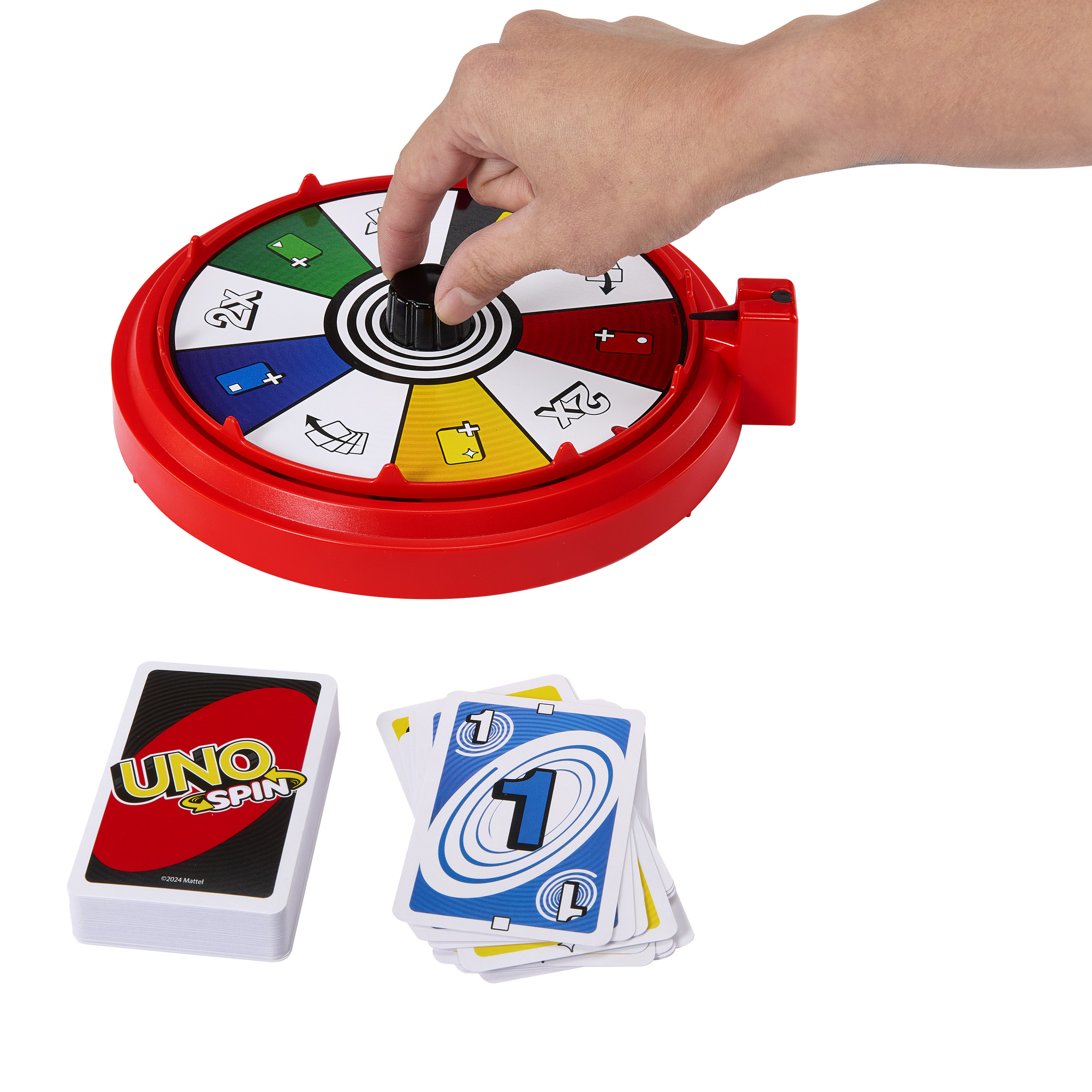 Hand dreht ein UNO Spin-Rad. Karten mit der Zahl 1 sind unten links. Ein Kartenspiel befindet sich links.