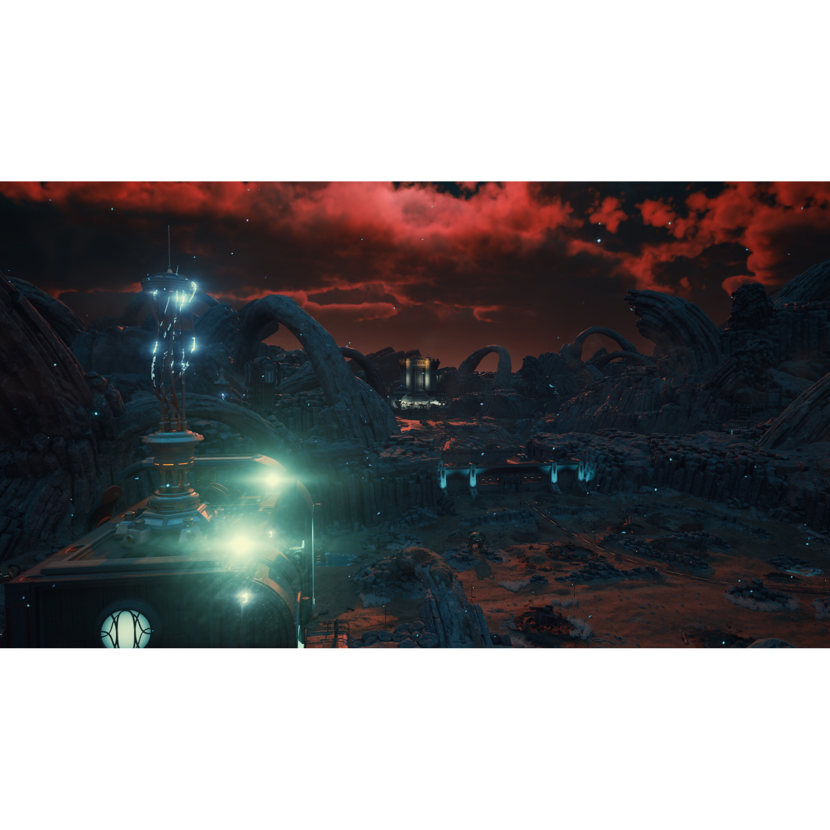 Paisaje de ciencia ficción con estructuras, arcos y cielo rojo. Un edificio con luces en primer plano. Terreno rocoso y edificios distantes.