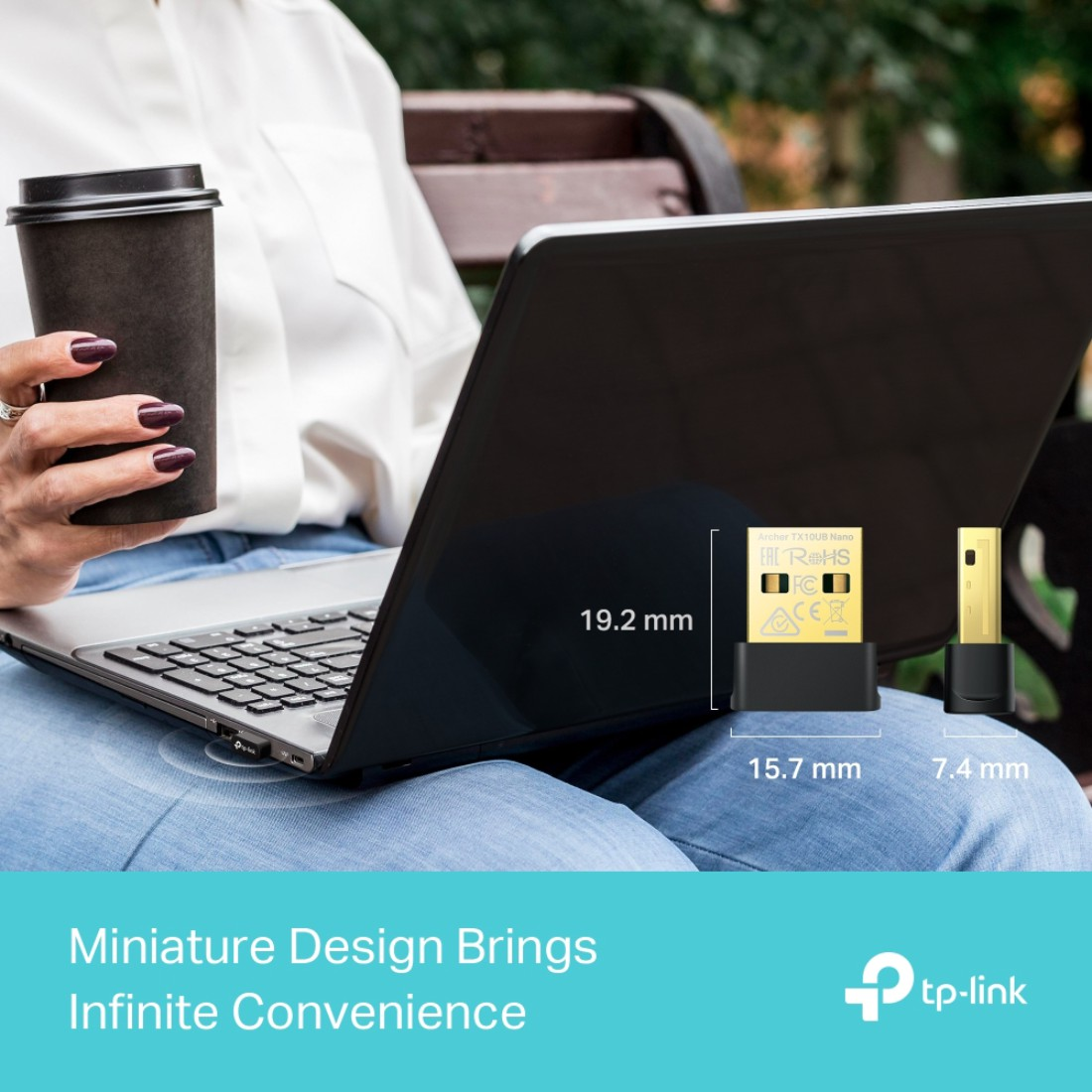 Eine Person benutzt einen Laptop und hält einen Kaffeebecher. Ein USB-Adapter befindet sich neben dem Laptop mit Größenangaben.