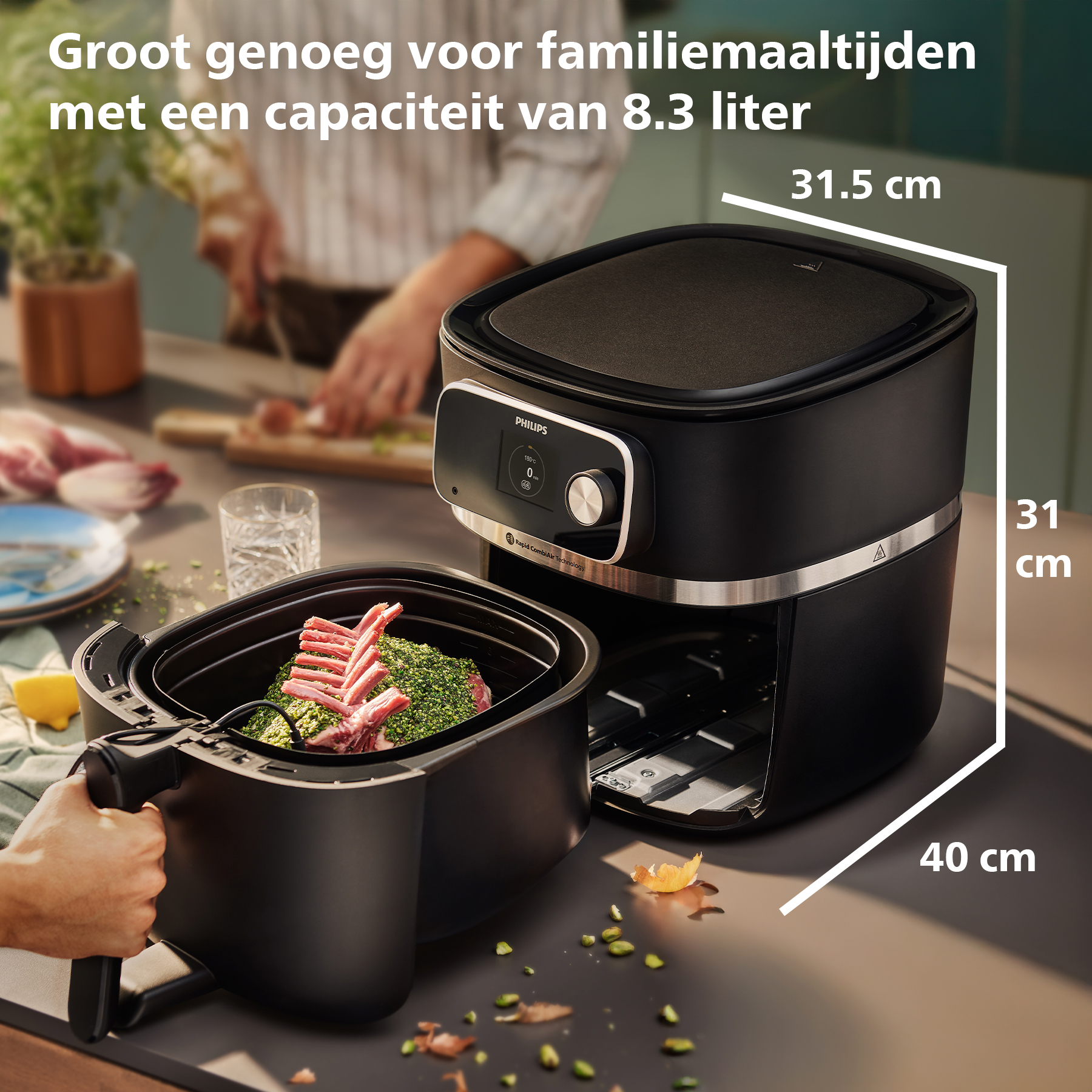 Black Philips air fryer with rack of lamb inside. Dimensions are 31.5x31x40 cm. A person is in the background.
