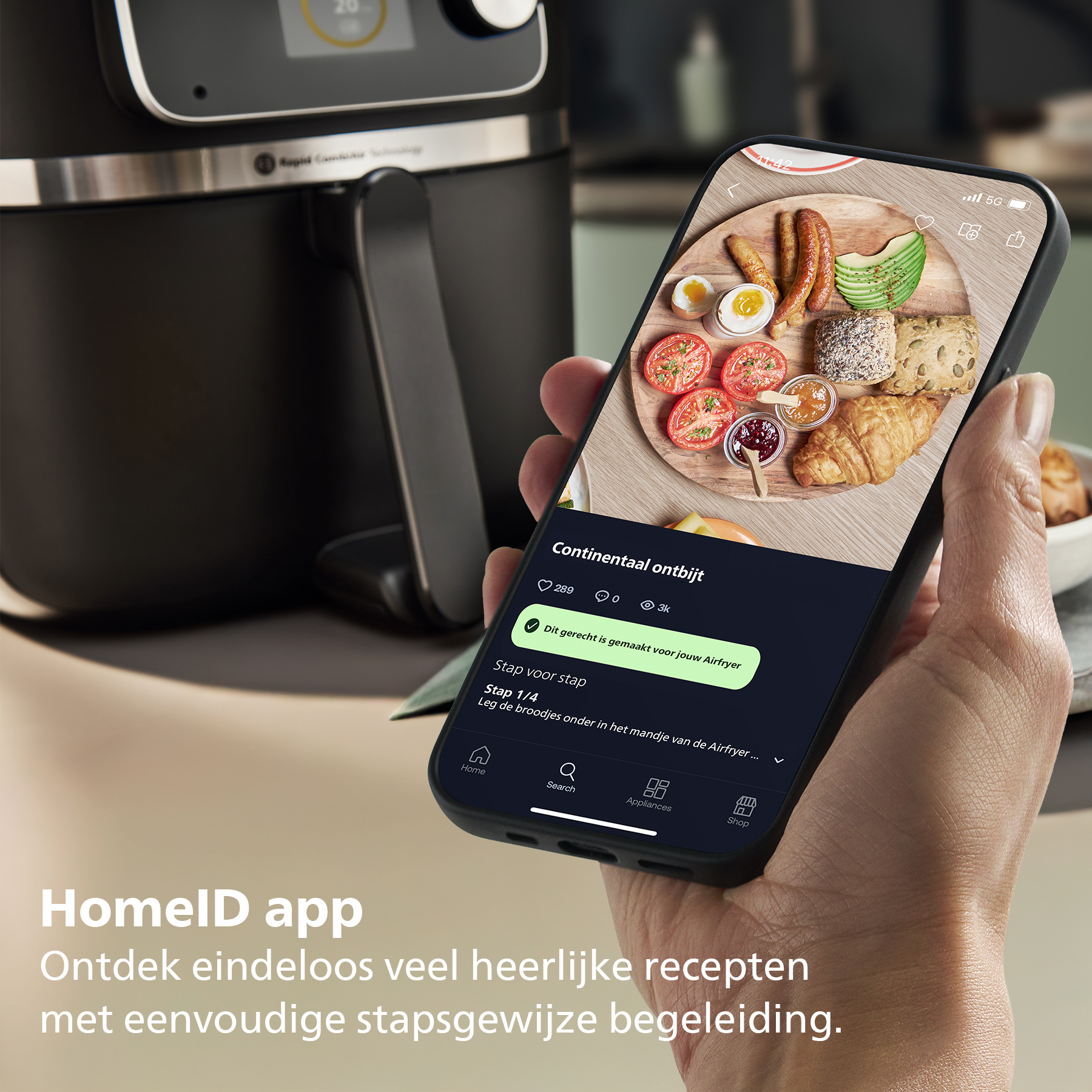 A hand holds a phone showing breakfast. An air fryer is visible in the background.