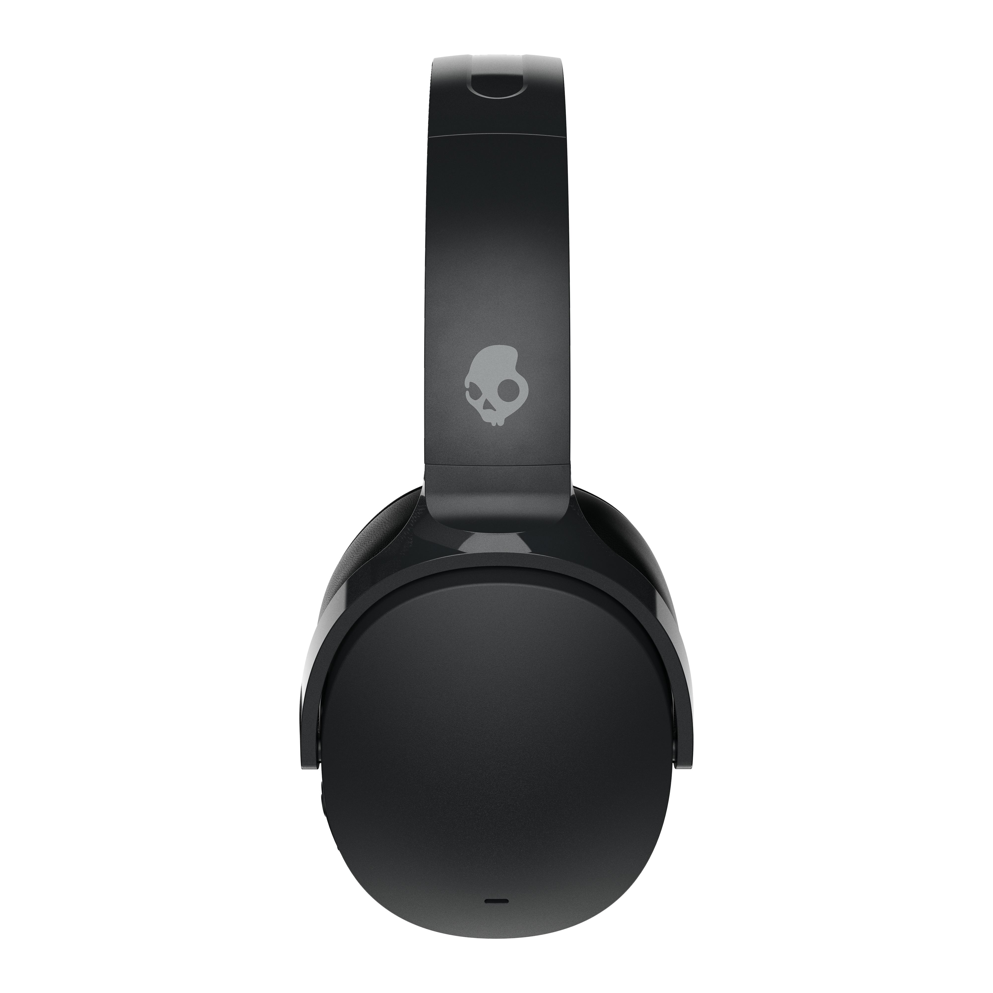 Fekete Skullcandy fejhallgató fekete háttéren. A fejhallgató középen van, koponya logóval a fejpánton.