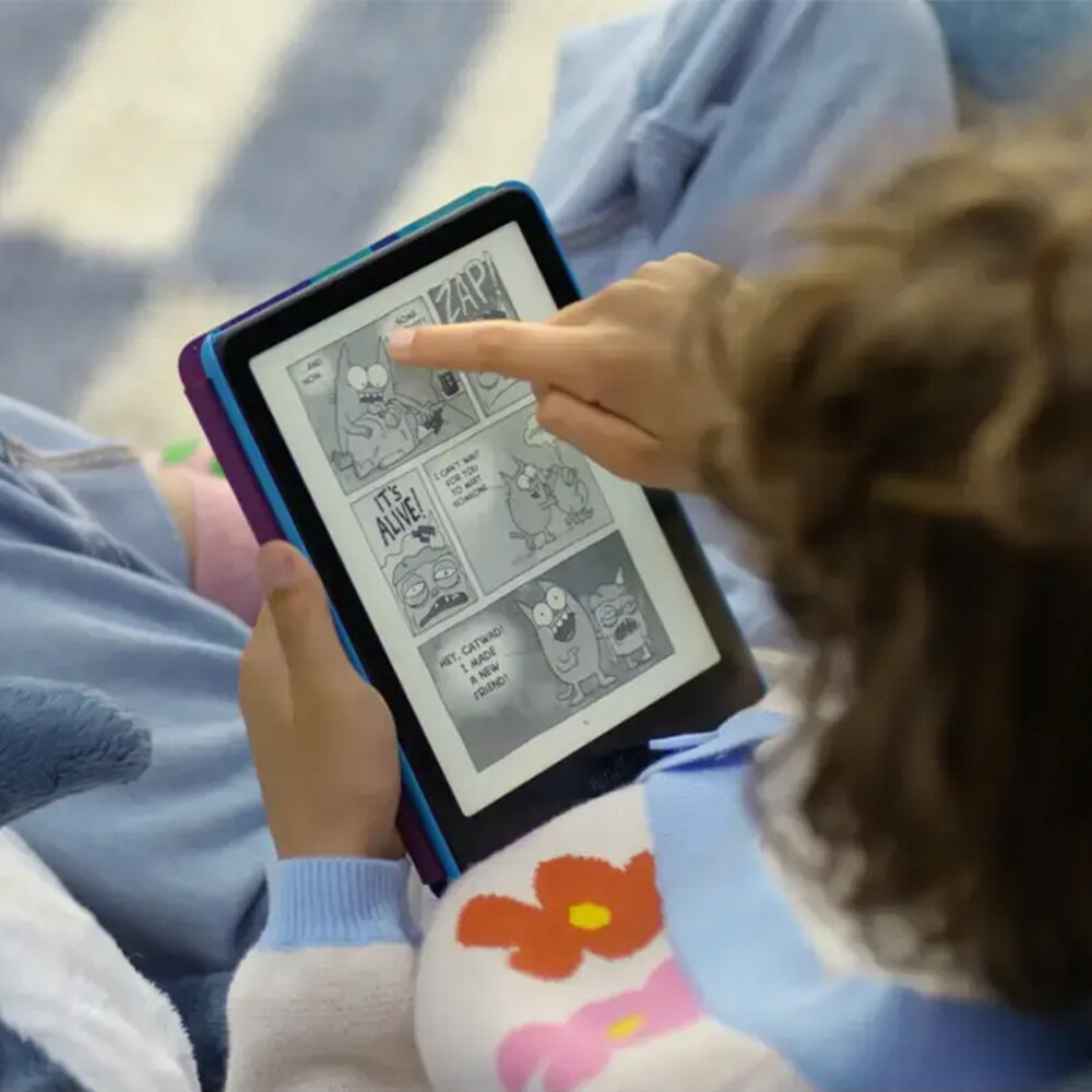 Dziecko czyta e-booka z komiksem. Palec dziecka wskazuje na komiks. E-book jest w fioletowo-niebieskim etui.