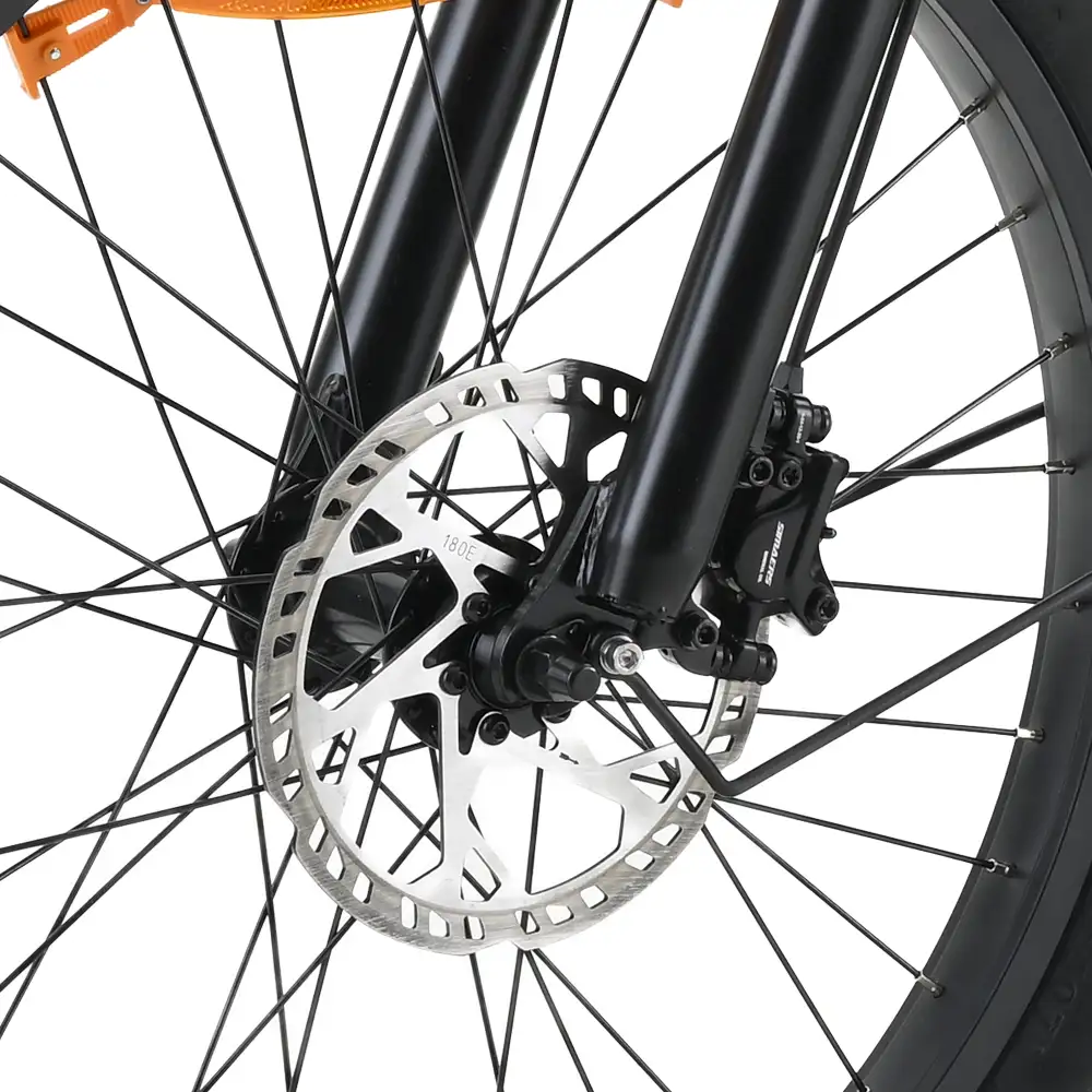 Primer plano de una rueda de bicicleta con freno de disco. Radios negros irradian desde el centro. El rotor del freno es plateado y las horquillas son negras.