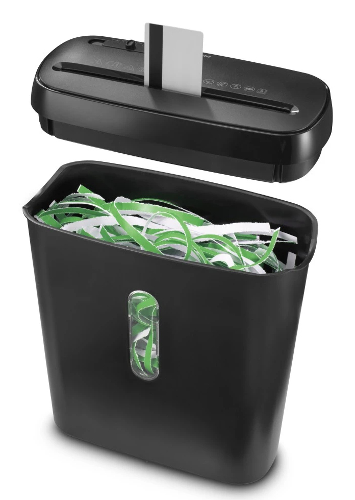 Una destructora de papel negra con una tarjeta de crédito blanca insertada. Papel triturado verde y blanco llena el contenedor.