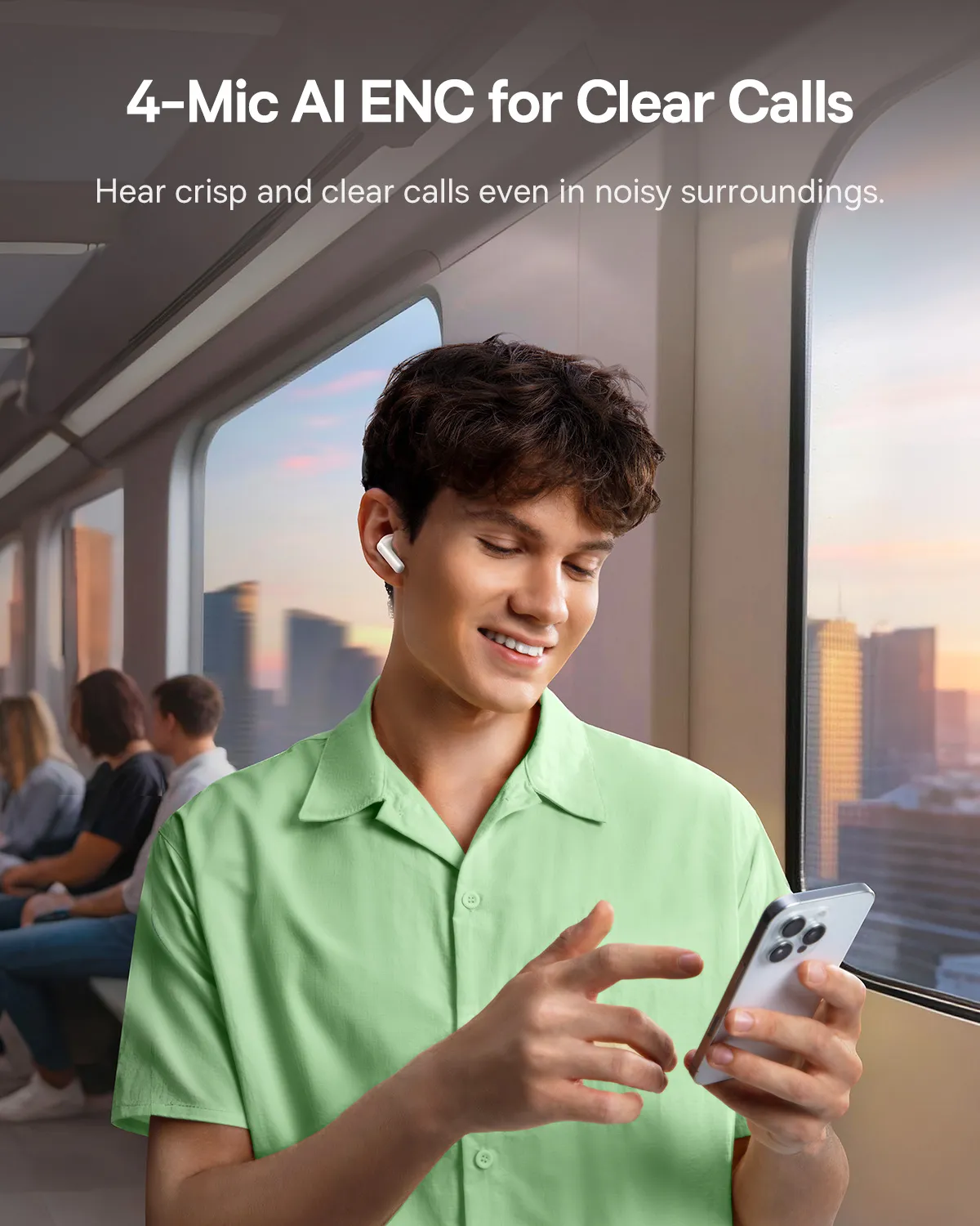 Un homme avec des écouteurs tient un téléphone, souriant. Il est dans un train, avec d'autres passagers flous en arrière-plan.