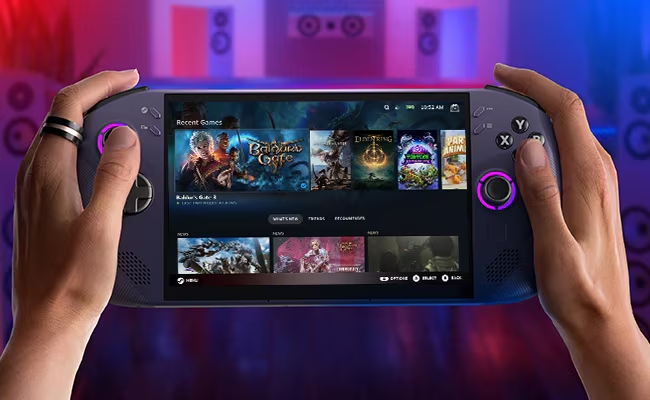 Mains tenant une console de jeux portable, affichant une bibliothèque de jeux. Appareil violet et noir, écran lumineux, fond sombre.